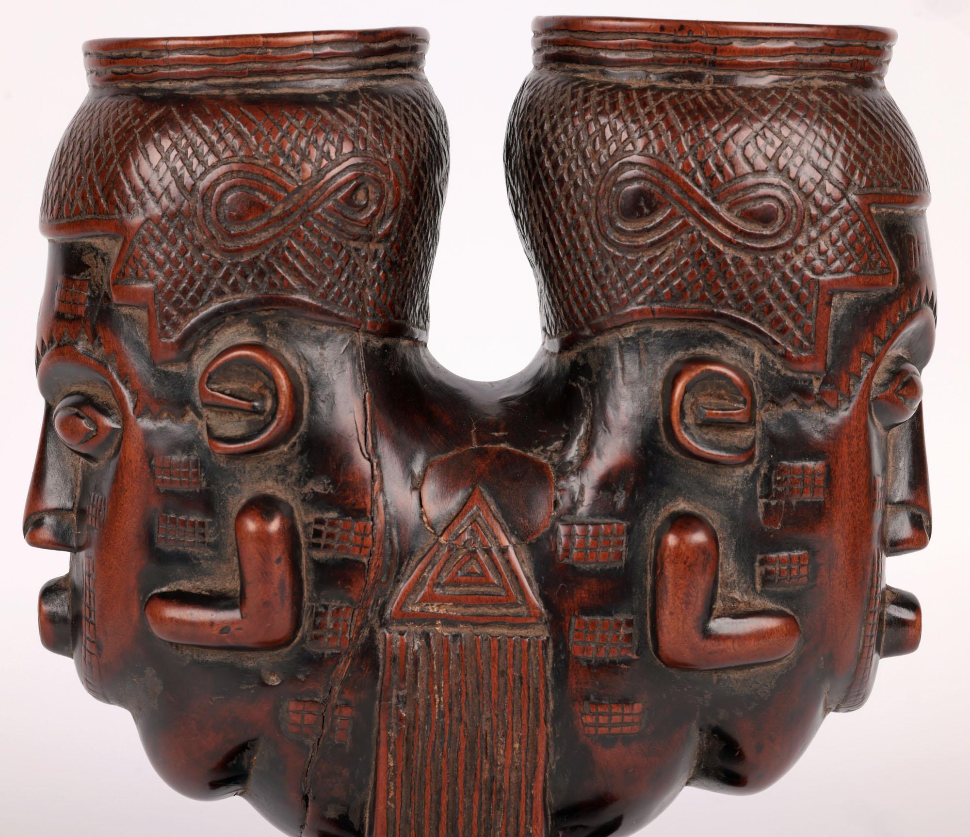 An unusual and exceptionally carved Central African tribal anthropomorphic wooden double head palm wine cup originating from the Kuba Kingdom and dating from the 20th century. 
The Kuba kingdom produced its best artwork at the height of its power in