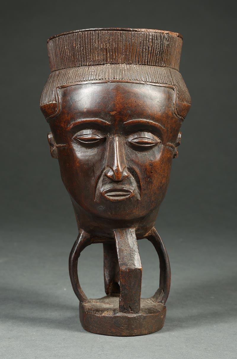 Kuba tribal African palm wine cup, Congo, Africa.

A early 20th century Kuba palm wine cup with sweetly carved face and four part openwork base. 10 3/4 inches high, old small chips to rim.
 
