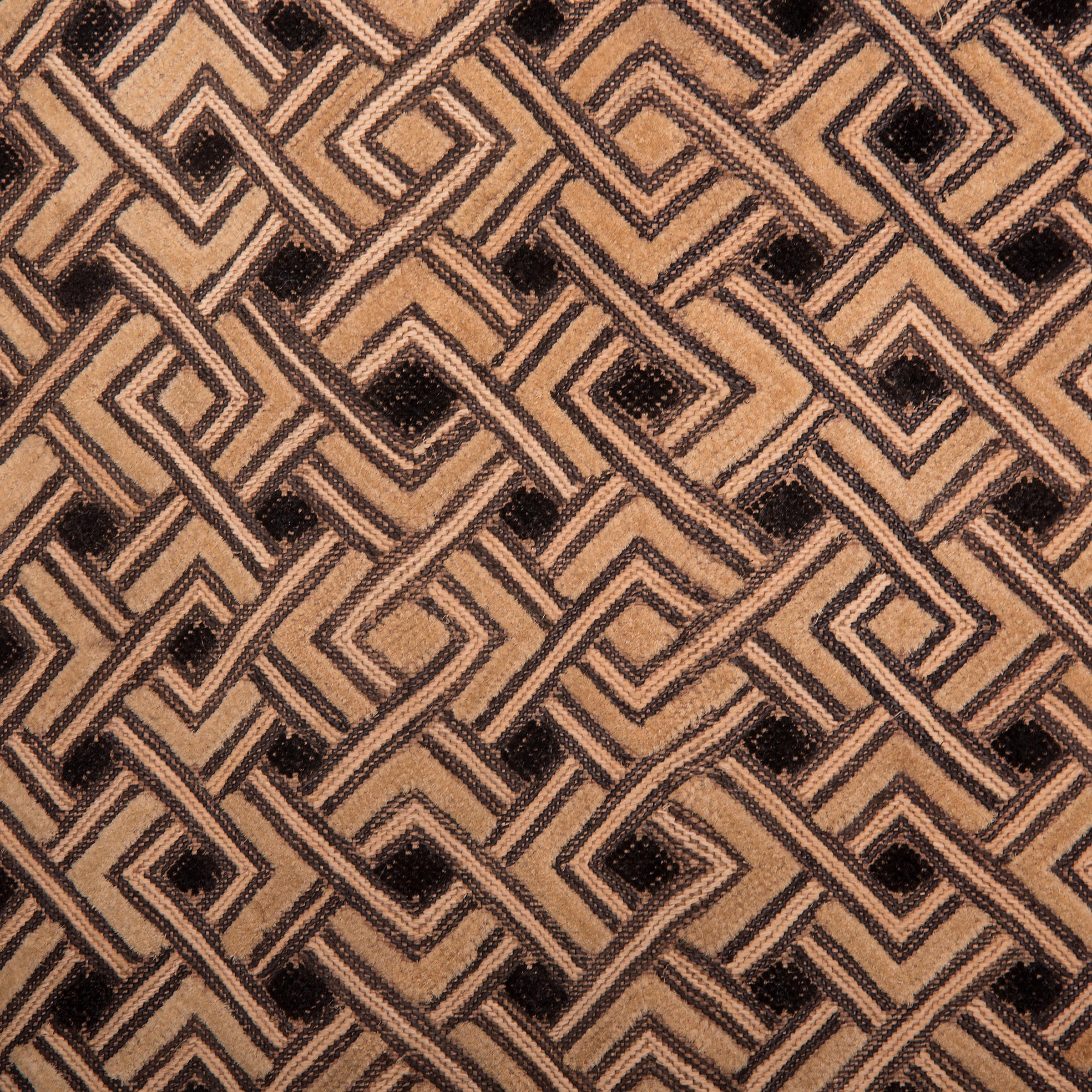 Visually dynamic and highly textured, this raffia panel expresses the irregular, geometric patterns typical of Kuba textile art. Created by an artisan of the Kuba people of the Democratic Republic of the Congo, this form of woven textile is made by