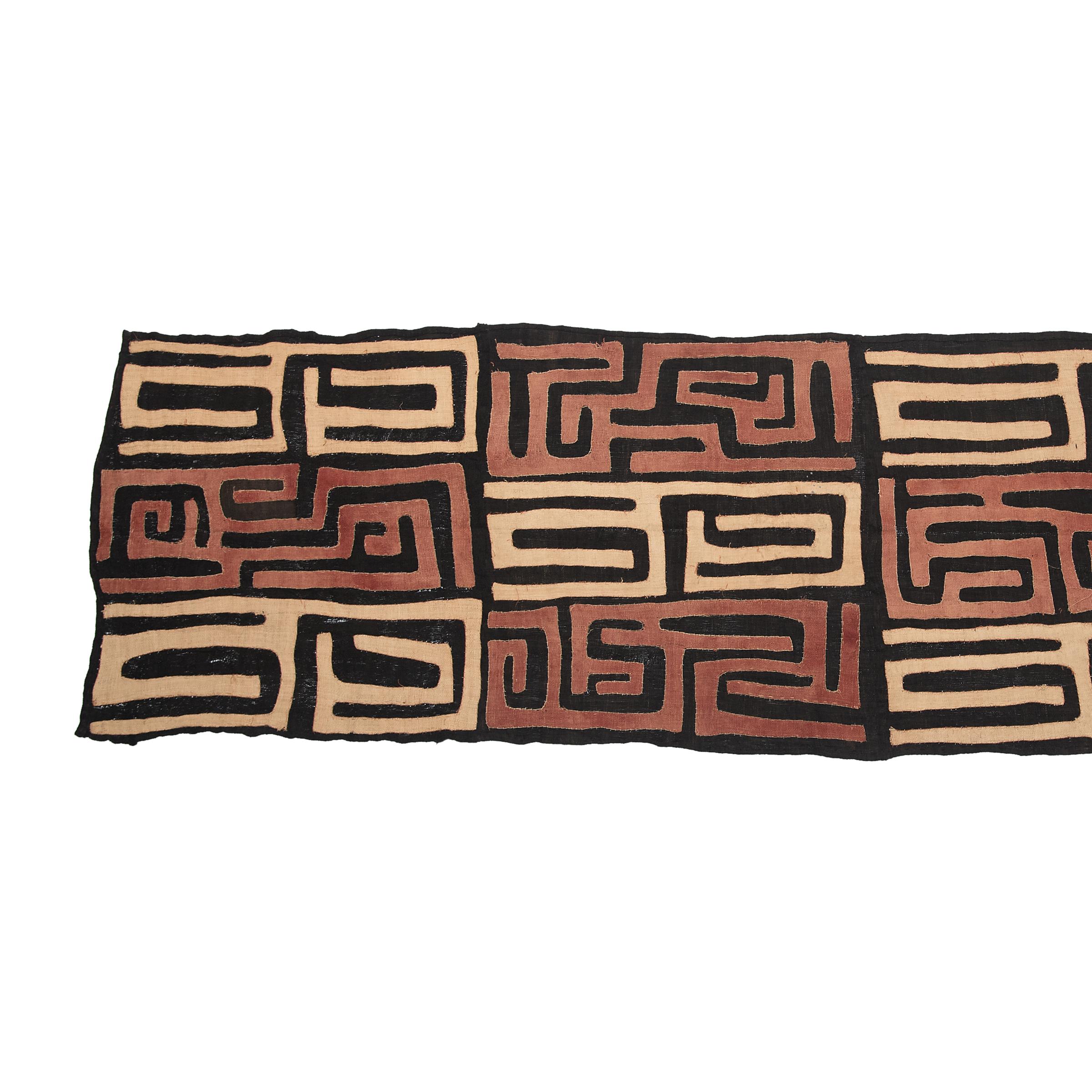 Visually dynamic and highly textured, this raffia textile expresses the irregular, geometric patterns typical of Kuba textile art. Created by an artisan of the Kuba People of the Democratic Republic of the Congo, this textile form is a wrapped skirt