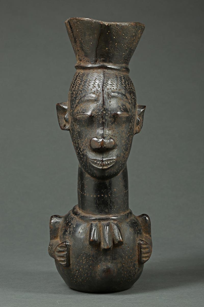 Kuba tribal African palm wine cup, Congo, Africa

A large Kuba palm wine cup with large face and stylized body. 12 1/2 inches high, old stabile repair to lip.
 