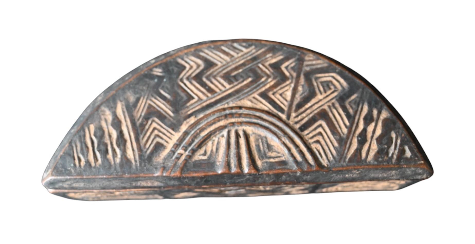 Kuba Tukula Box – Early 1900s, D.R. Congo

Dimensions: 17.5 cm x 7.5 cm
Material: Carved wood with pigment traces

A finely carved semi-circular Kuba tukula box, dating from the early 20th century. The box is richly decorated with traditional