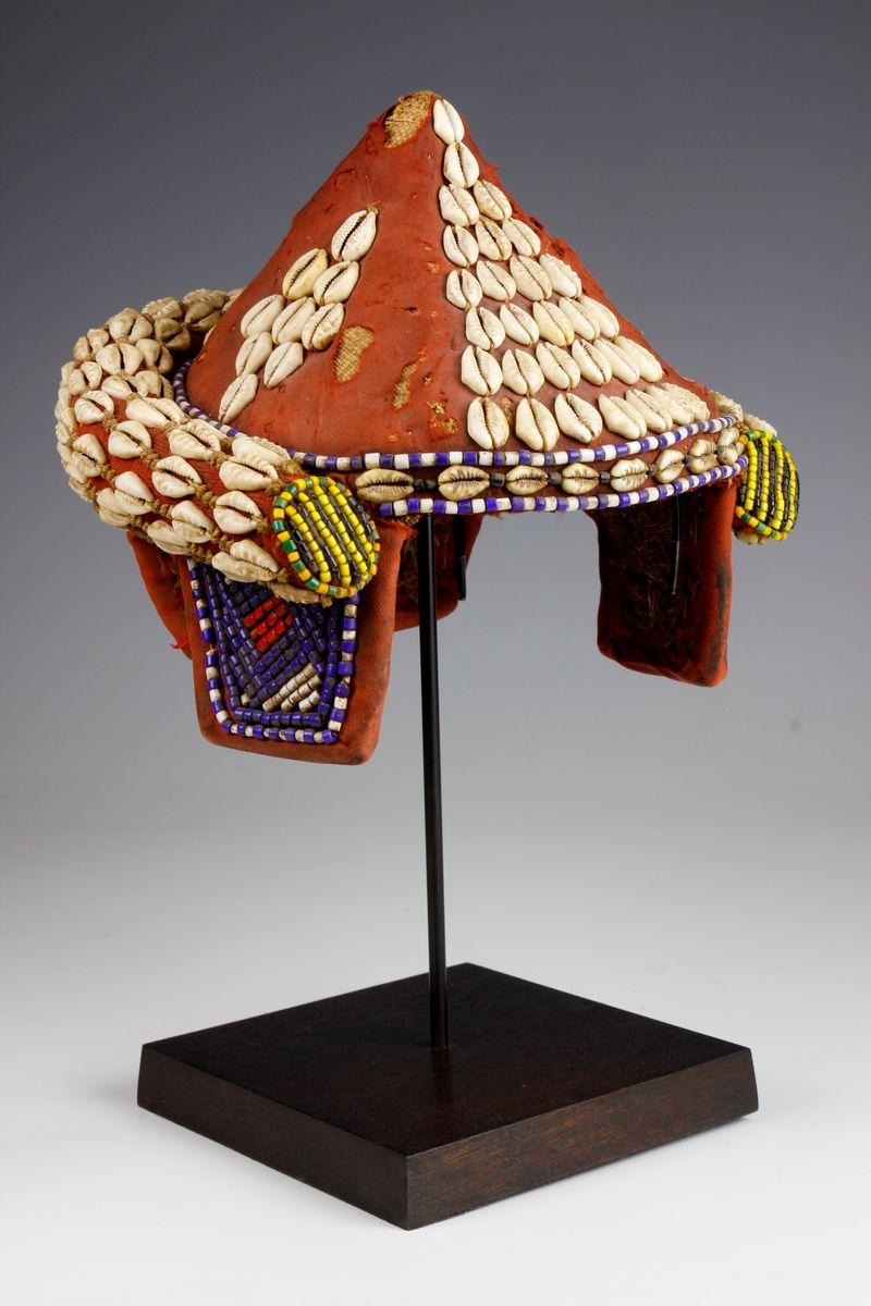 In Kuba society, title holding is dominated by men; there are only two titles held by women. Headdresses were and are the most visible expression of one’s standing within the intricate Kuba system of leadership and title holding. This Kuba headdress