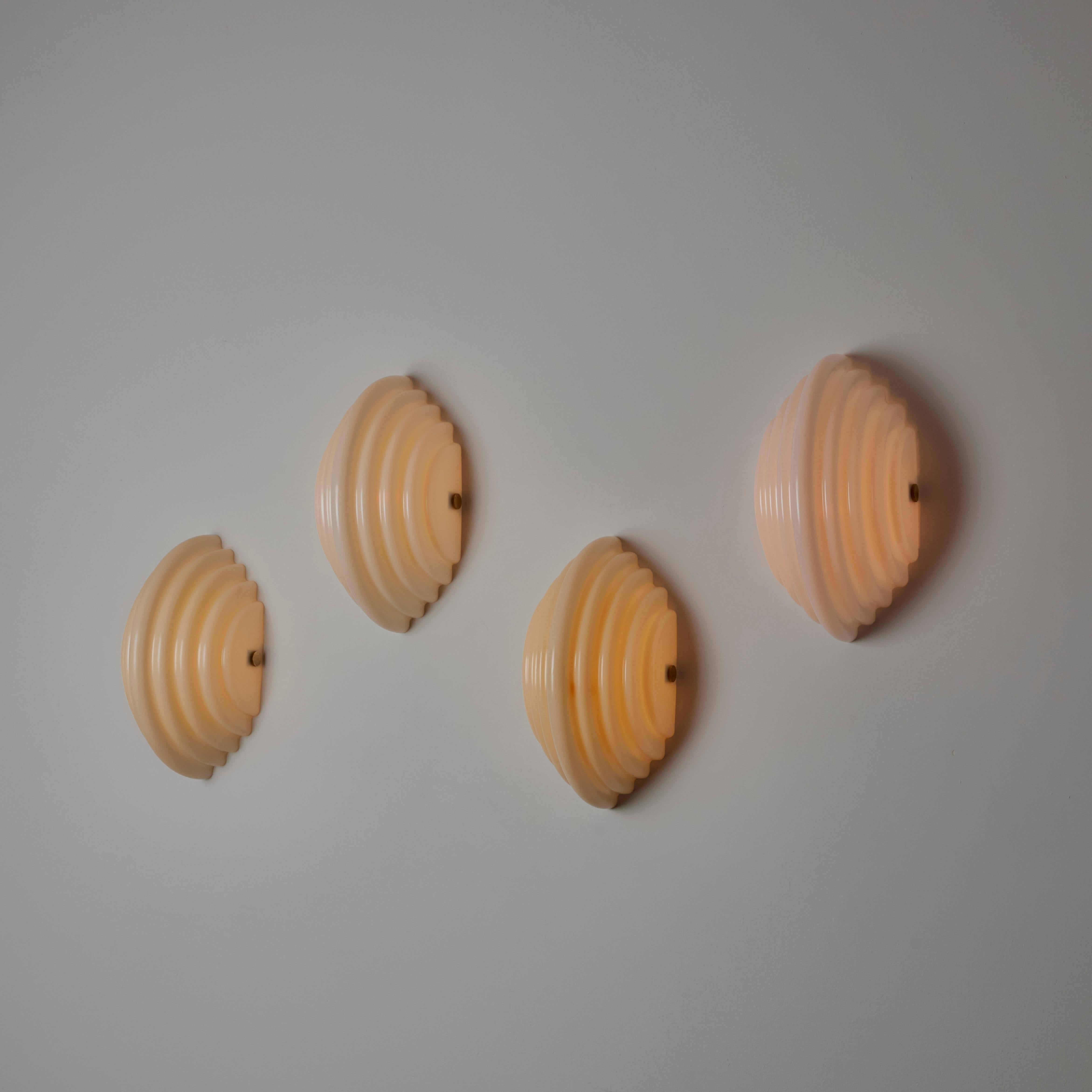 'Kai 2' sconces by Kazuhide Takahama for Sirrah. Designed and manufactured in Italy, circa the 1980s. Mollusc shaped molded acrylic shells make up the entire body of these contemporary sconces. Each sconce obtains a single E27 socket type, adapted
