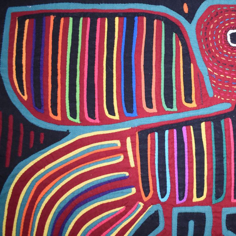 Une grande tapisserie en collage de tissus aux couleurs vives représentant un oiseau avec un poisson dans la bouche. Cette pièce de tissu spectaculaire présente des pièces de tissu géométriques soigneusement découpées, façonnées et cousues ensemble