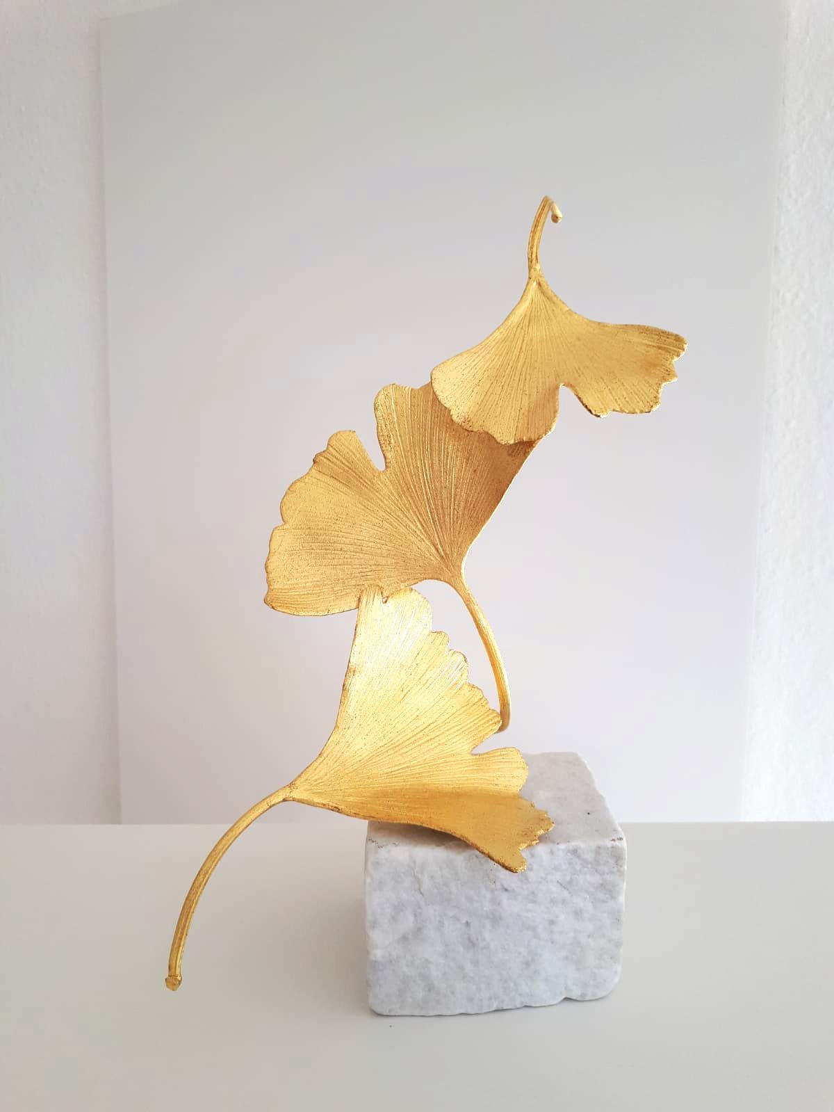 Artist: Kuno Vollet
Title: 3 Golden Gingko Leaves
Materials: Cast brass, gold leaf, white marble base
Size: 25 x 9 x 9 cm

This small elegant original bronze cast sculpture by German artist Kuno Vollet brings nature and energy into any art