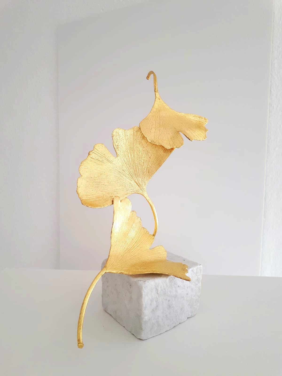 Artist: Kuno Vollet
Title: 3 Golden Gingko Leaves
Materials: Cast brass, gold leaf, white marble base
Size: 25 x 9 x 9 cm

This small elegant original bronze cast sculpture by German artist Kuno Vollet brings nature and energy into any art