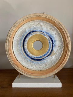 Diamante Infinito de K. Vollet - escultura circular dorada y azul sobre base de granito