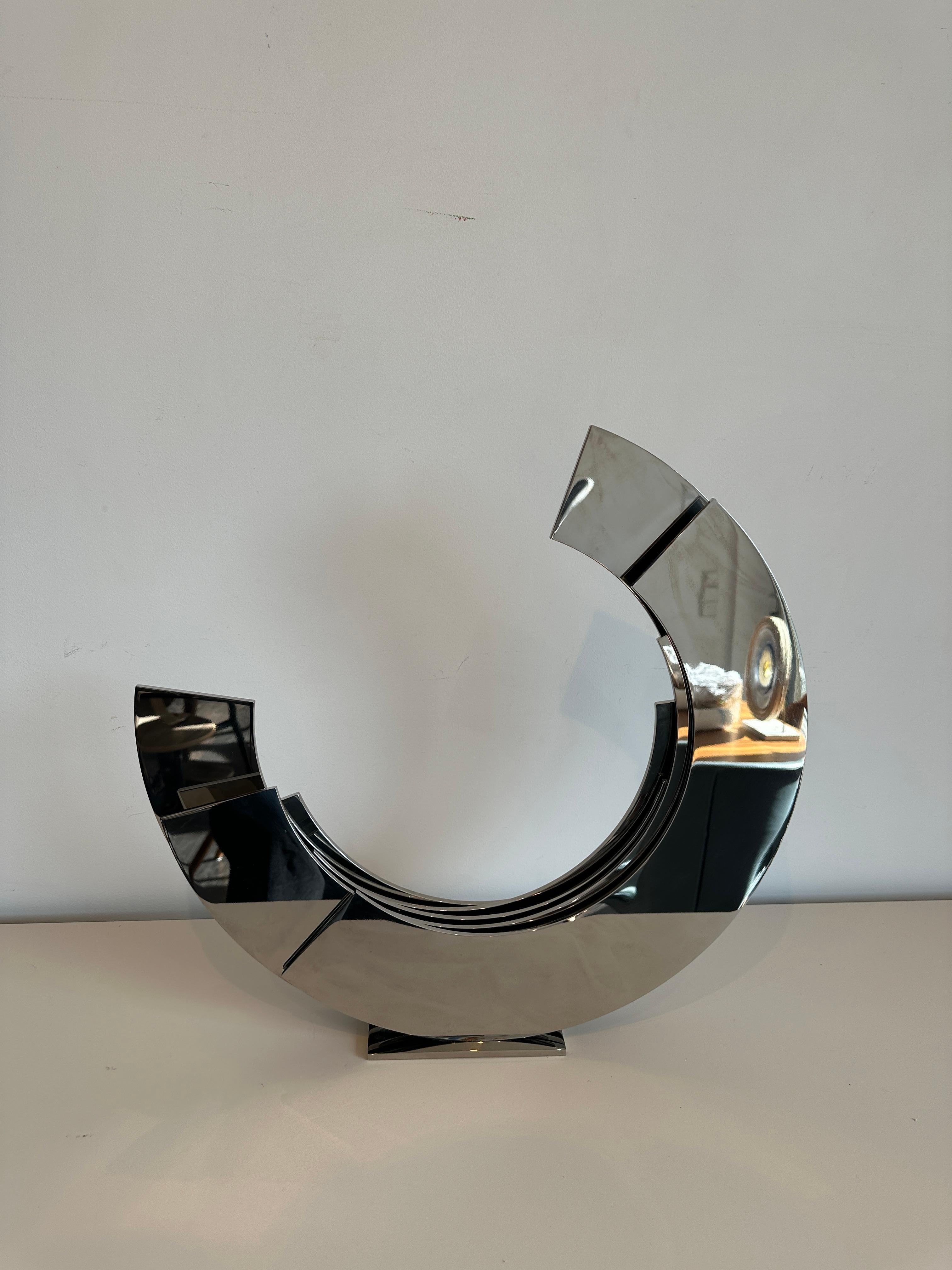 Contemporary Minimal Silver polished stainless steel sculpture. It is a stunning polished stainless steel and makes for an elegant statement in any garden, lobby or private home.

Kuno Vollet is a sculptor working with different materials such as