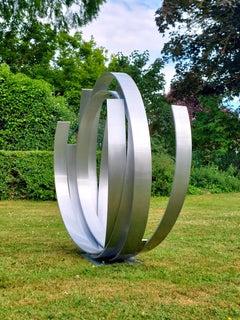 Órbita atemporal - Escultura contemporánea de aluminio plateado para exteriores