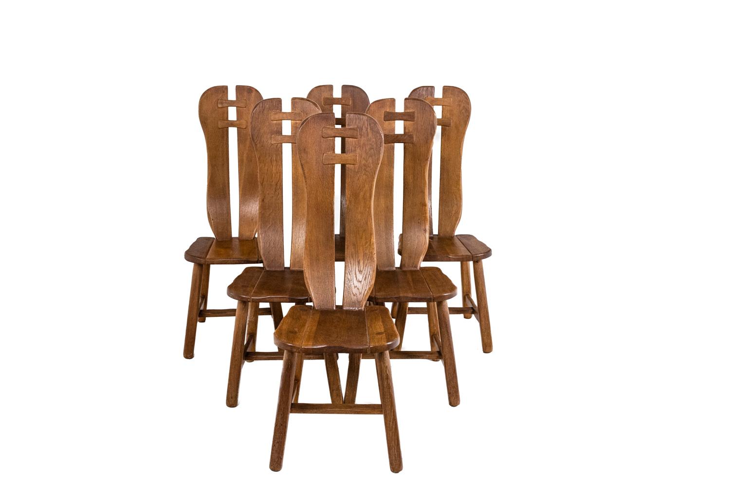 Kunstmeubelen De Puydt, edited by.

Table and six chairs in oak. Round table Chairs with high back, curved and elongated shape. Openwork backrest joined by two wooden slats. Base joined by two spacer bars.

Belgian work realized in the