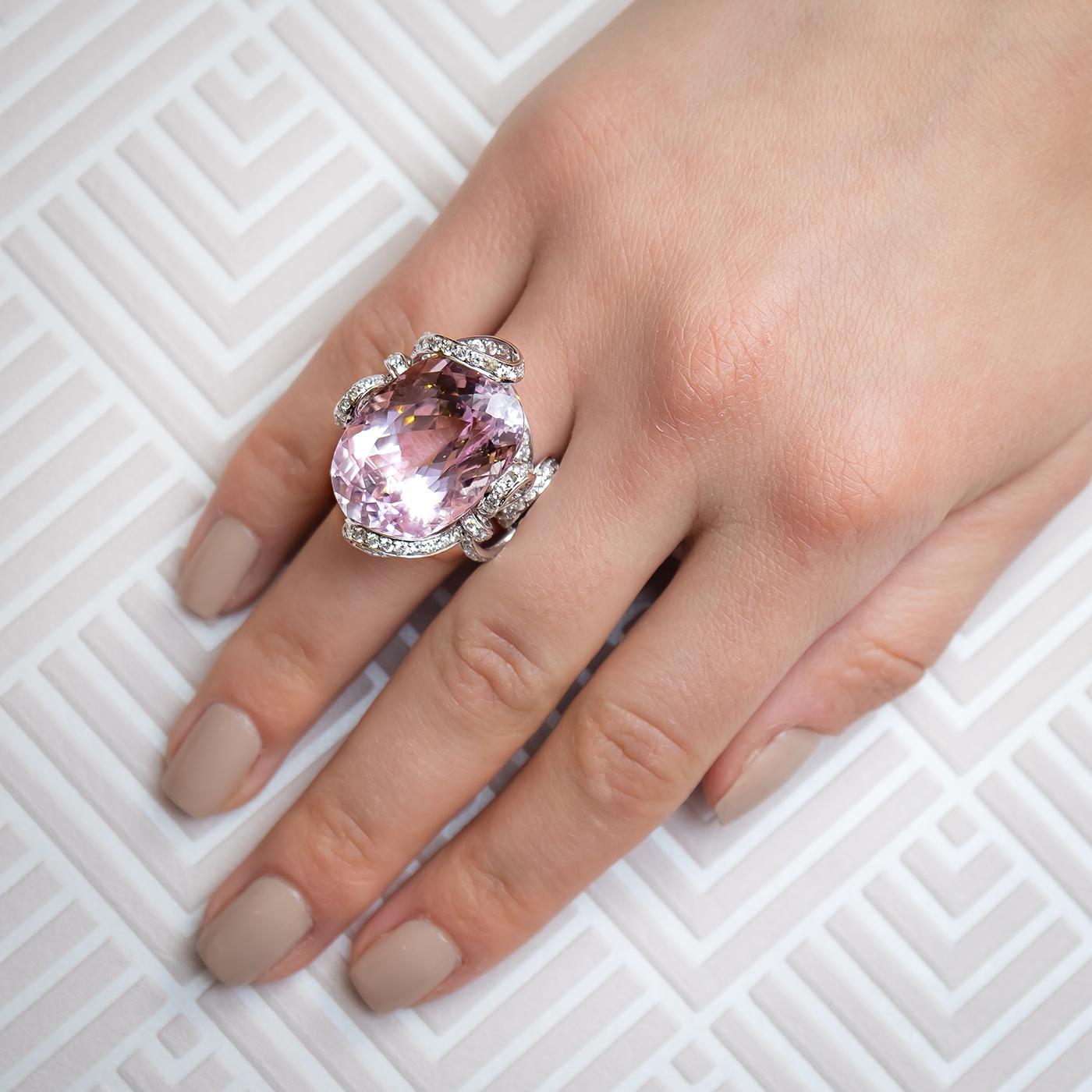 A kunzite ring, set with a 46.97ct oval kunzite, with 2.86ct of small round brilliant-cut diamonds set in twisting loops and bows holding then centre stone. Mounted in platinum.
The finger size is approximately UK size M / USA size 6.