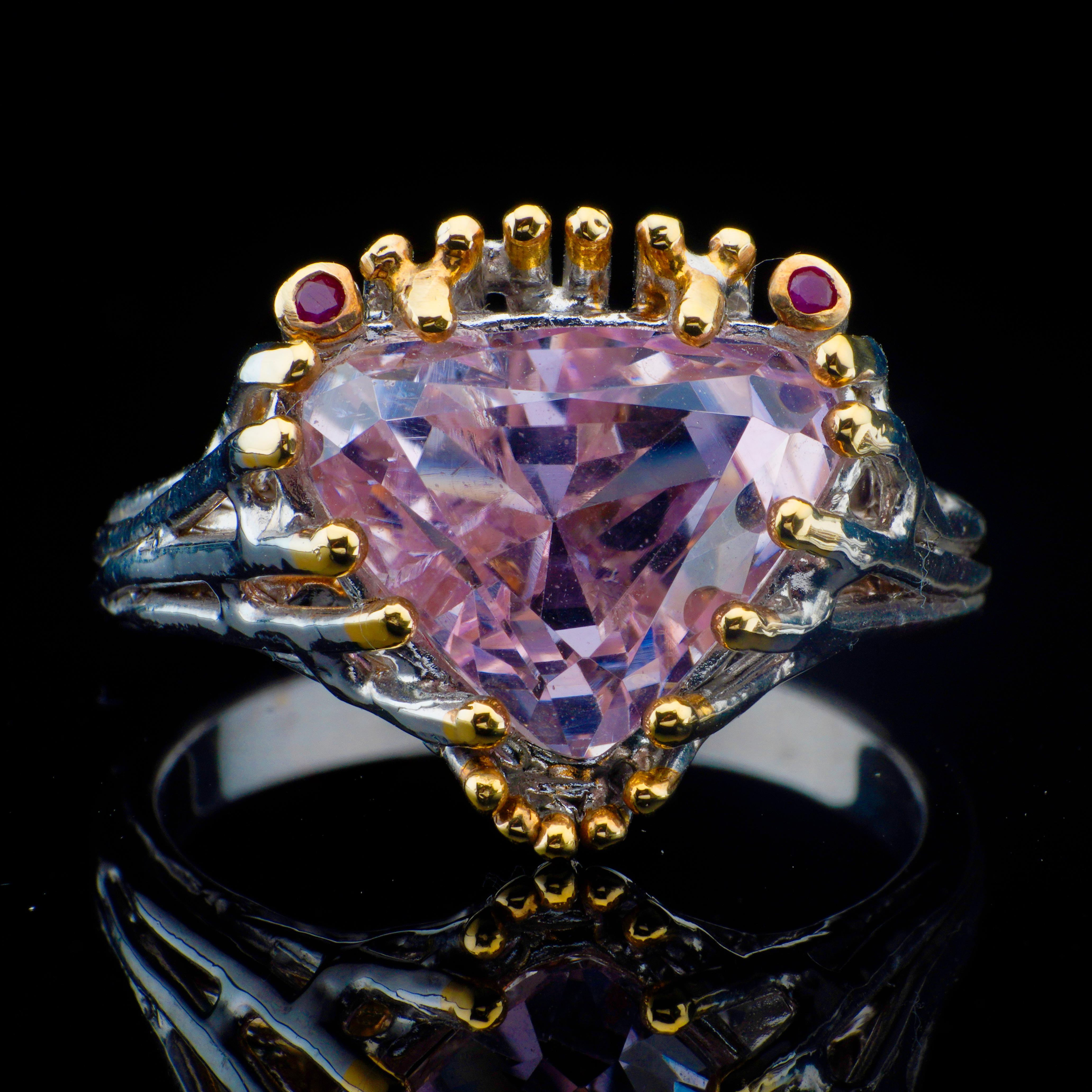 Dieser atemberaubende, handgefertigte Ring zeigt einen brillanten Kunzit im Billionen-Schliff: ein natürlich vorkommender rosafarbener Edelstein, der für seine strahlende Klarheit und seine beruhigenden lavendelfarbenen bis magentafarbenen Töne