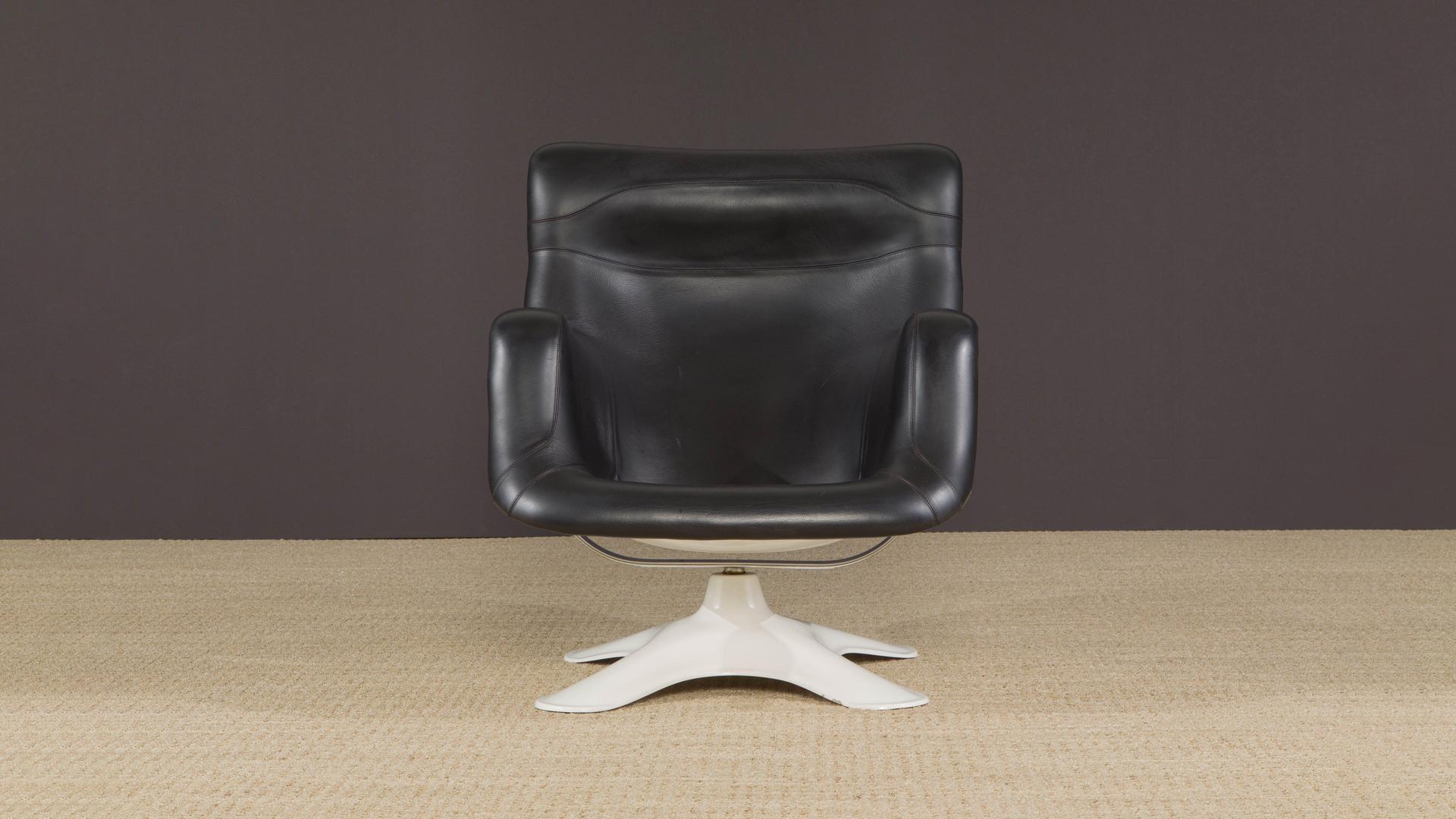 This 'Karuselli' swivel lounge chair by Yrjo¨ Kukkapuro, originally designed in 1964, features a strong fiberglass shell, soft black leather upholstery, and a chromed steel swivel mechanism that rotates and tilts to achieve the most comfortable