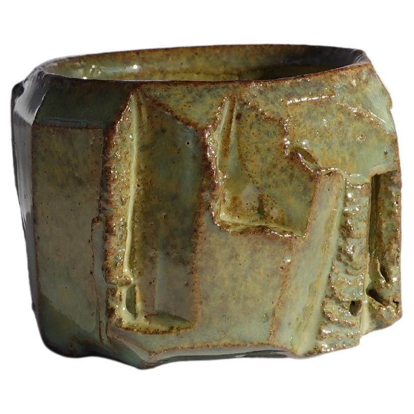 Cette tasse à expresso a d'abord été tournée au tour, puis méticuleusement sculptée à la main selon la technique traditionnelle du kurinuki, permettant à la forme d'émerger intuitivement de l'argile. Chaque angle, arête et surface texturée révèle un