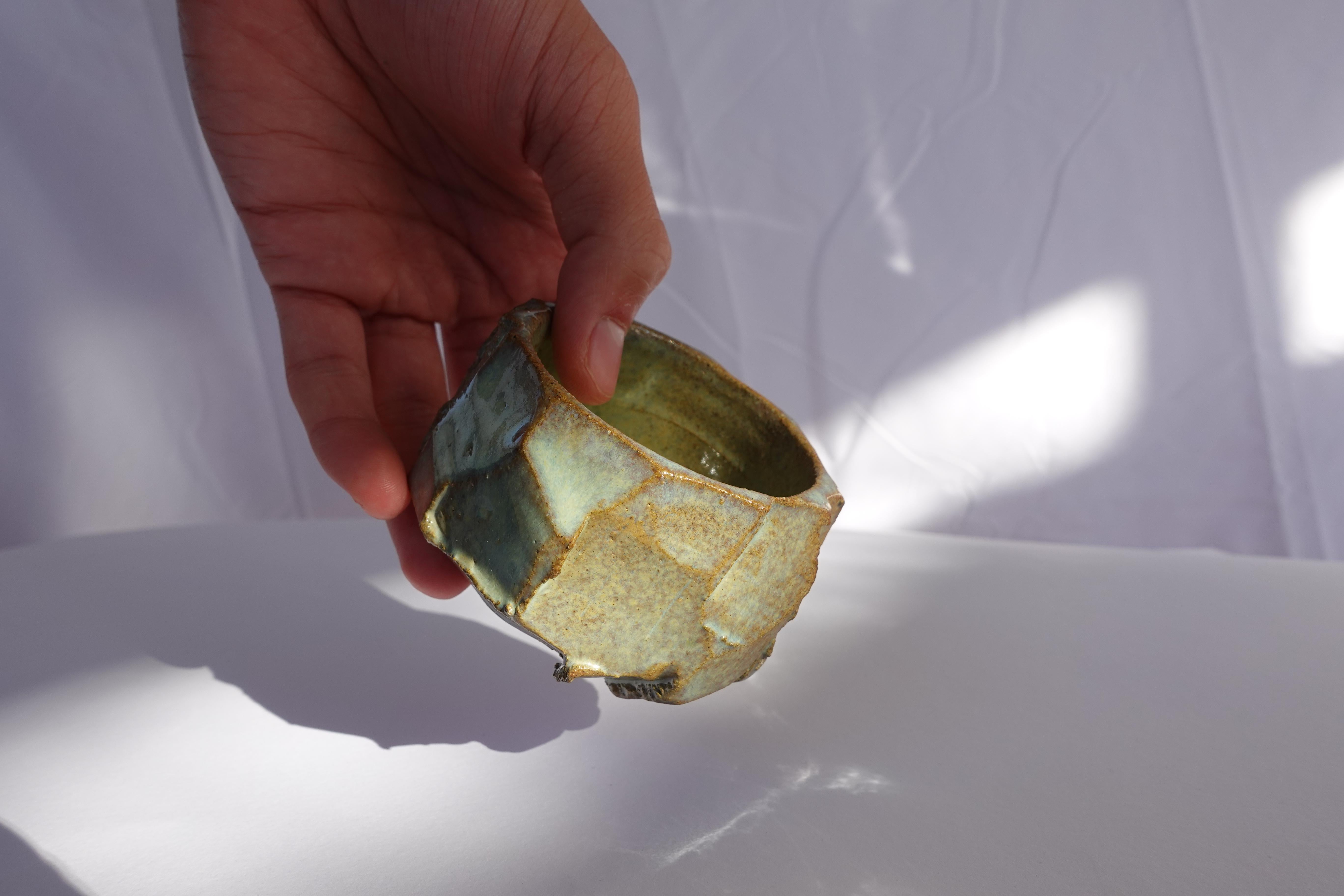 Cette tasse à expresso a d'abord été tournée au tour, puis méticuleusement sculptée à la main selon la technique traditionnelle du kurinuki, permettant à la forme d'émerger intuitivement de l'argile. Chaque angle, arête et surface texturée révèle un