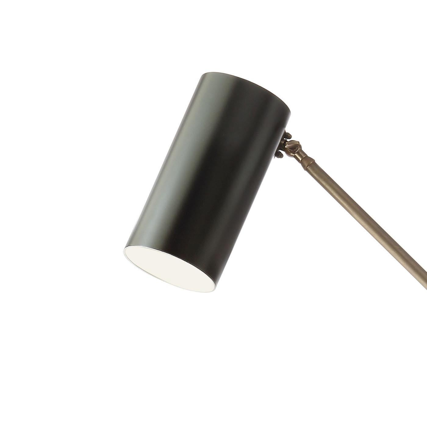 Cette lampe de bureau pratique présente une élégante structure en laiton avec une finition bronze qui peut être fixée sur n'importe quelle surface grâce à son système de support en laiton. Les deux fines tiges, reliées au milieu, permettent à la