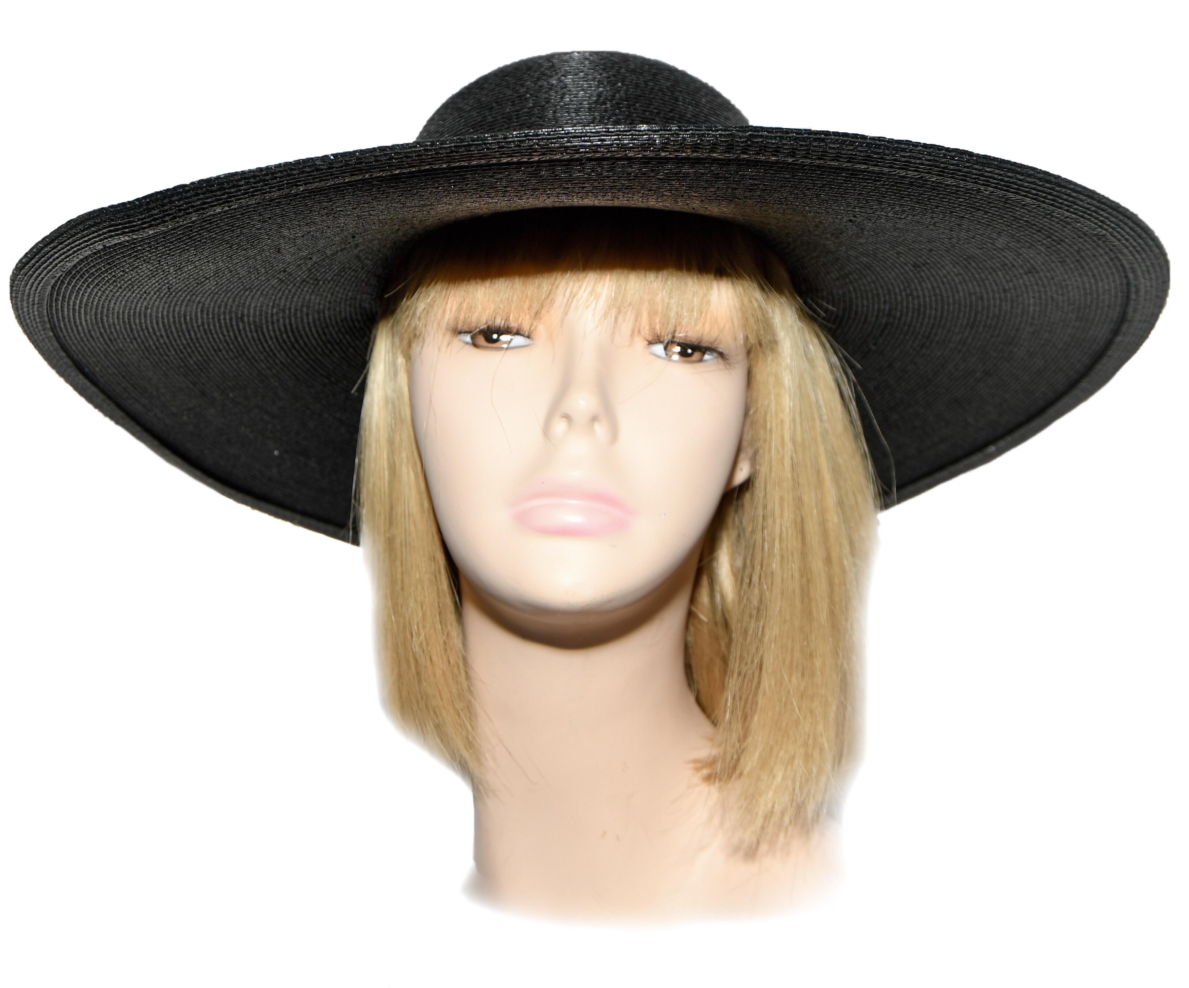 This wide brim black straw fedora hat created with glossy straw includes a black side bow hugging the head.  A label inside reading 