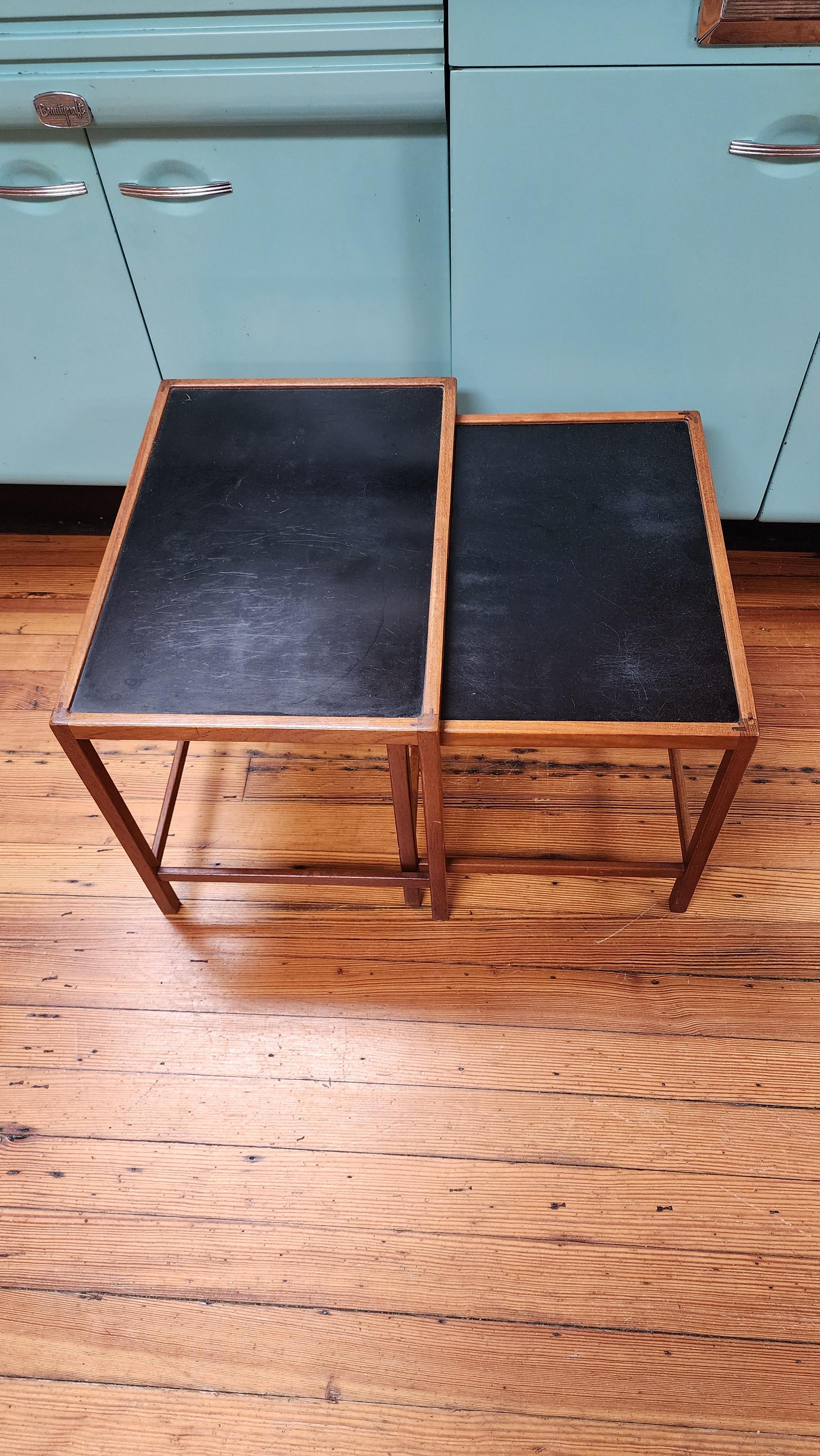 Cette paire de tables gigognes danoises en teck a été conçue par Kurt Ostervig dans les années 1950. La menuiserie d'angle est particulièrement bien exécutée, avec un assemblage à la main de type tenon et mortaise. 
Les tables s'emboîtent