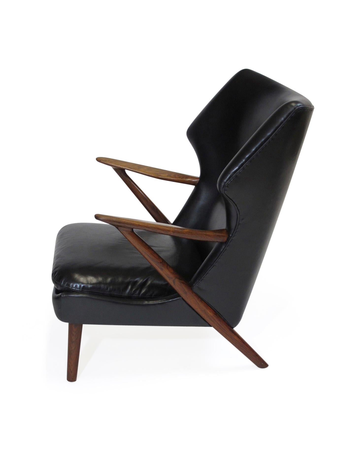 Midcentury lounge chair designed by Kurt Olsen for Slagelse Mobelvaerk, Model 221. Rare rosewood frame with sculpted wide arms, upholstered in new black leather to the exact specifications of original tailoring.
