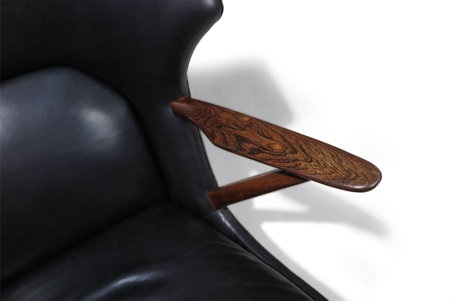 Mid-century lounge chair designed by Kurt Olsen for Slagelse Møbelværk, Model 221.
Typically crafted in teak, this rare version features a solid Brazilian rosewood frame with sculpted arms and is upholstered in the original black leather. The