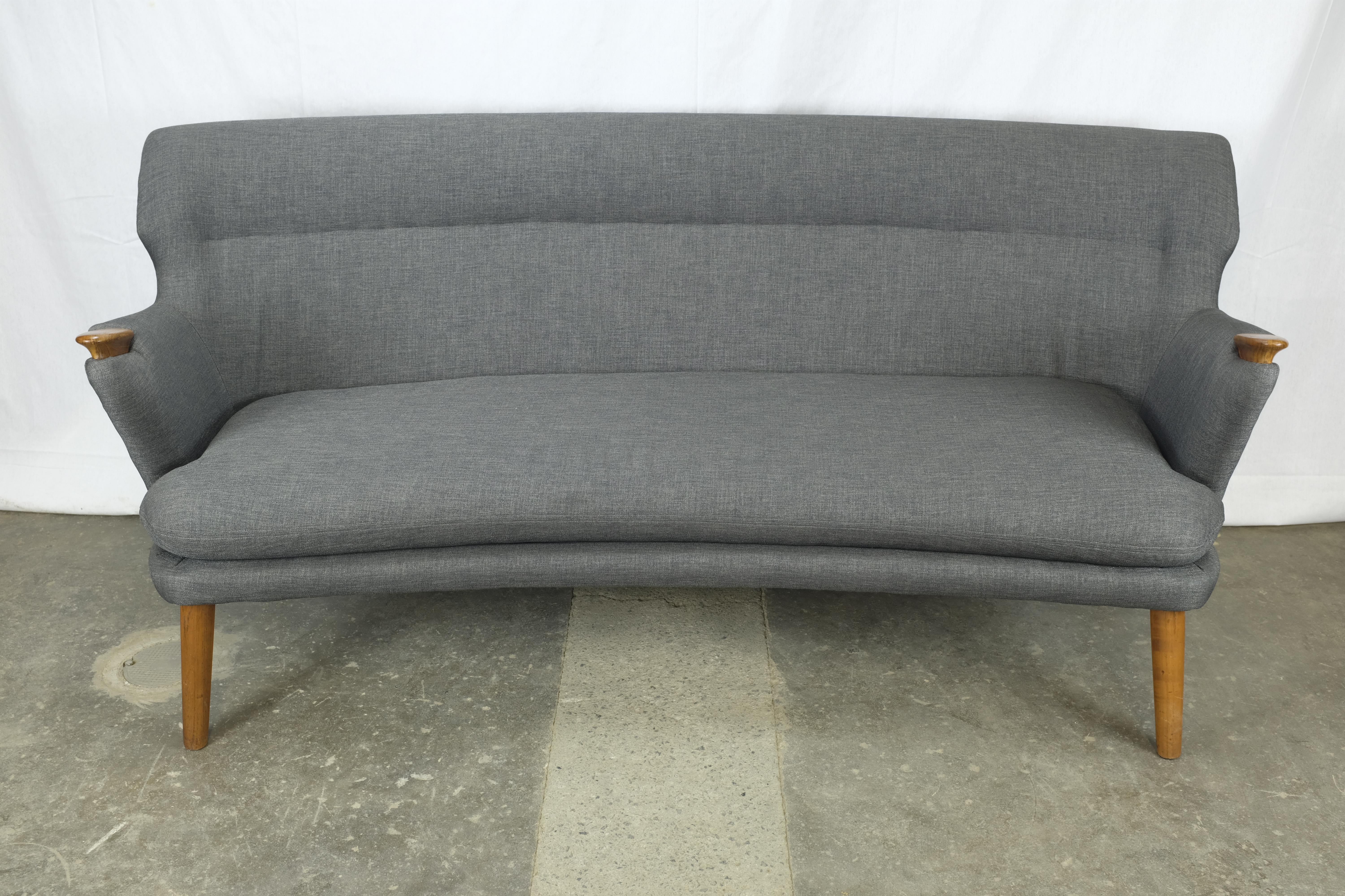 Sofa designed by Kurt Olsen and manufactured in Denmark by Slagelse Møbelvaerk. The back of the sofa has a gentle curve and the armrests have teak 'bear paw' teak arm caps.

The piece has been fully reupholstered with new webbing under the seat