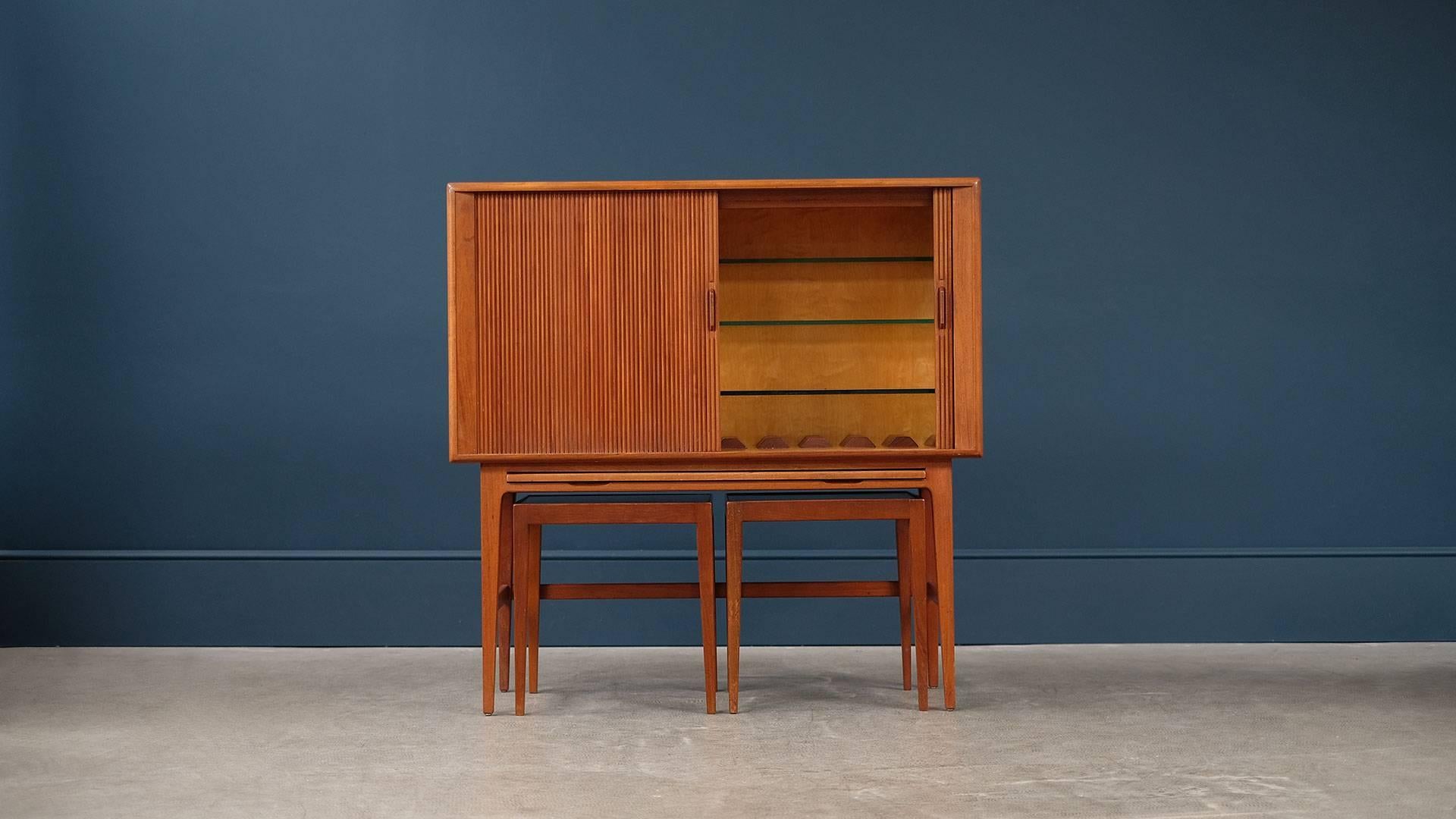 Amazing bar cabinet in beautiful patinated teak with reeded tambour doors and two occasional tables designed by Kurt Ostervig for KP Mobler, Denmark. Rare and fantastic piece with great proportions.