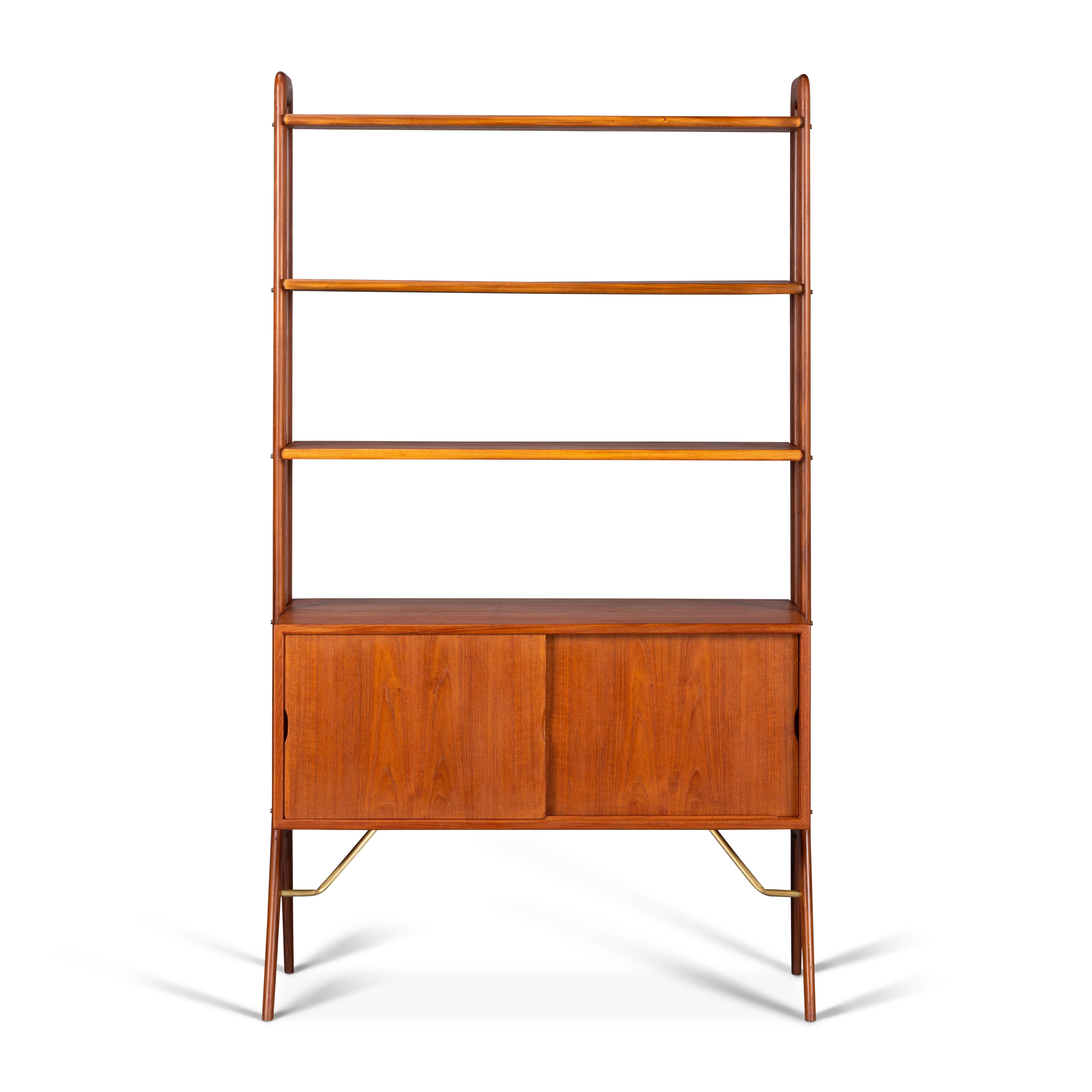 This Danish Mid-Century Modern freestanding room divider/bookshelf is a top -quality unit. Design by Kurt Ostervig. This chest features three height adjustable shelves, two sliding door larger lower cabinet supported by brass rods. This wonderfully