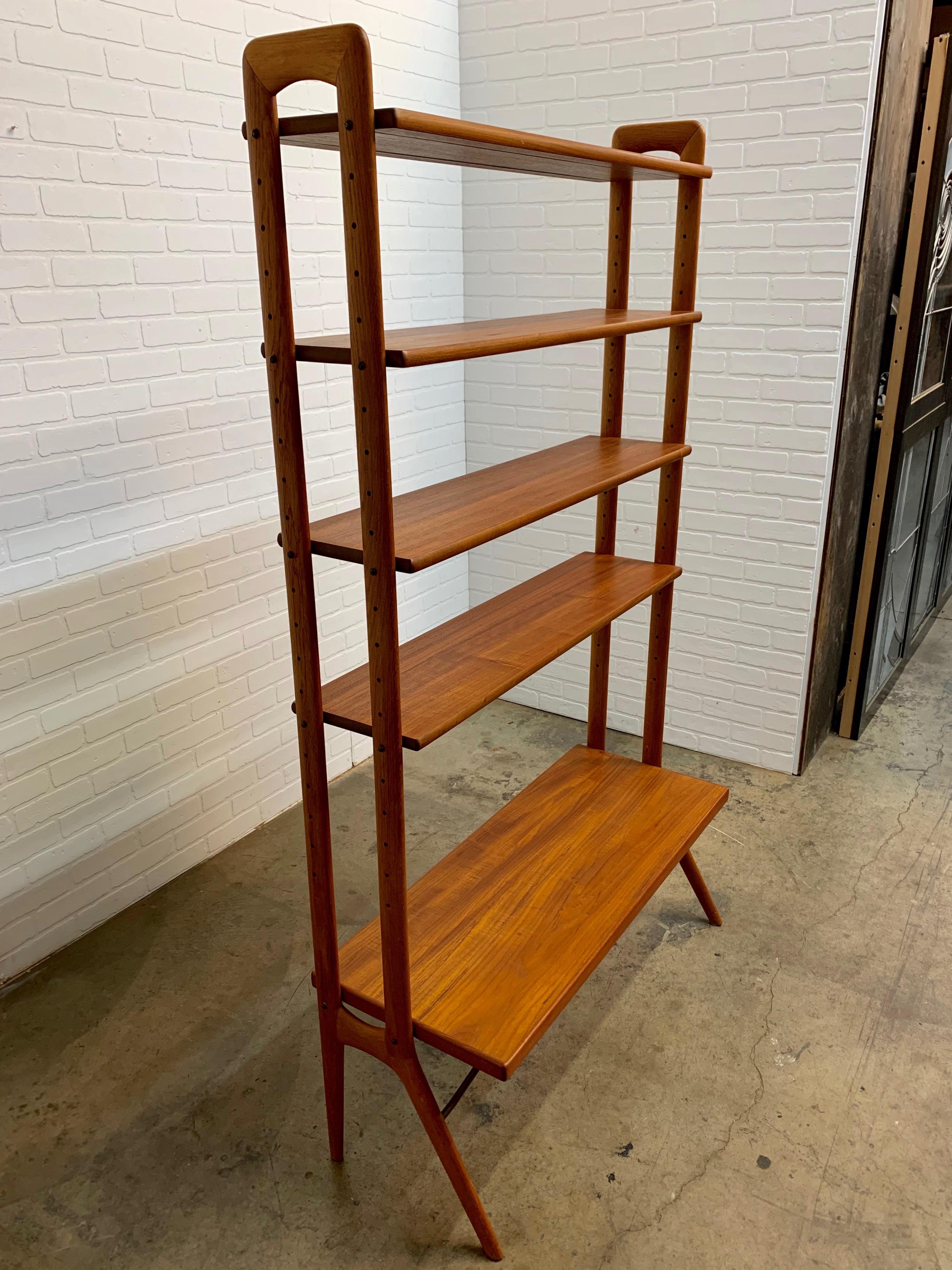 Modular and adjustable Danish modern teak wood bookshelf or room divider with brass support structure.