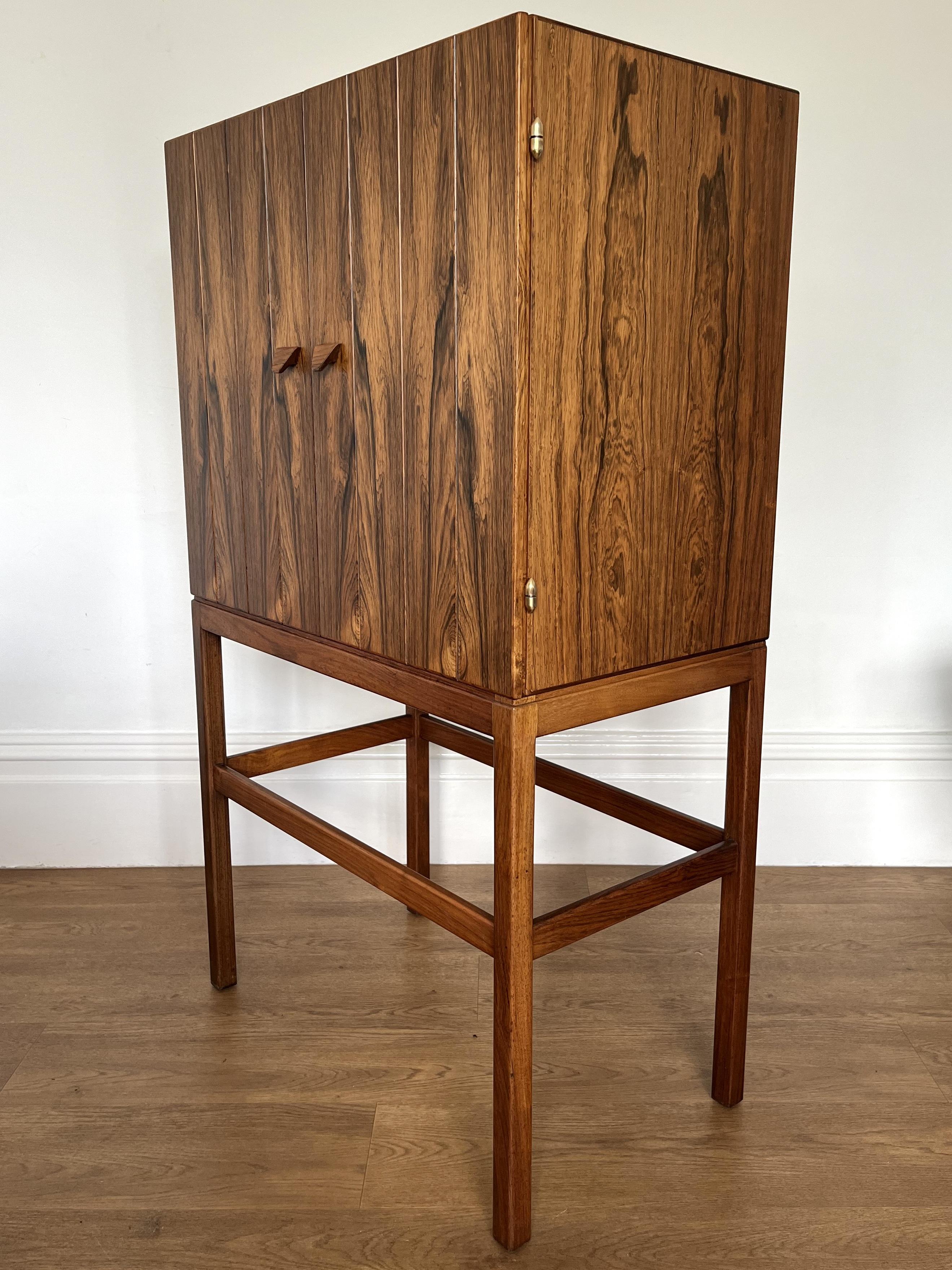 Stunning rosewood drinks cabinet designed by Kurt Østervig for KP Mobler, Denmark in the early 1960s.

Superbly crafted with great attention to detail. The cabinet features a rosewood exterior and satinwood lined interior with 3 shelves and 3