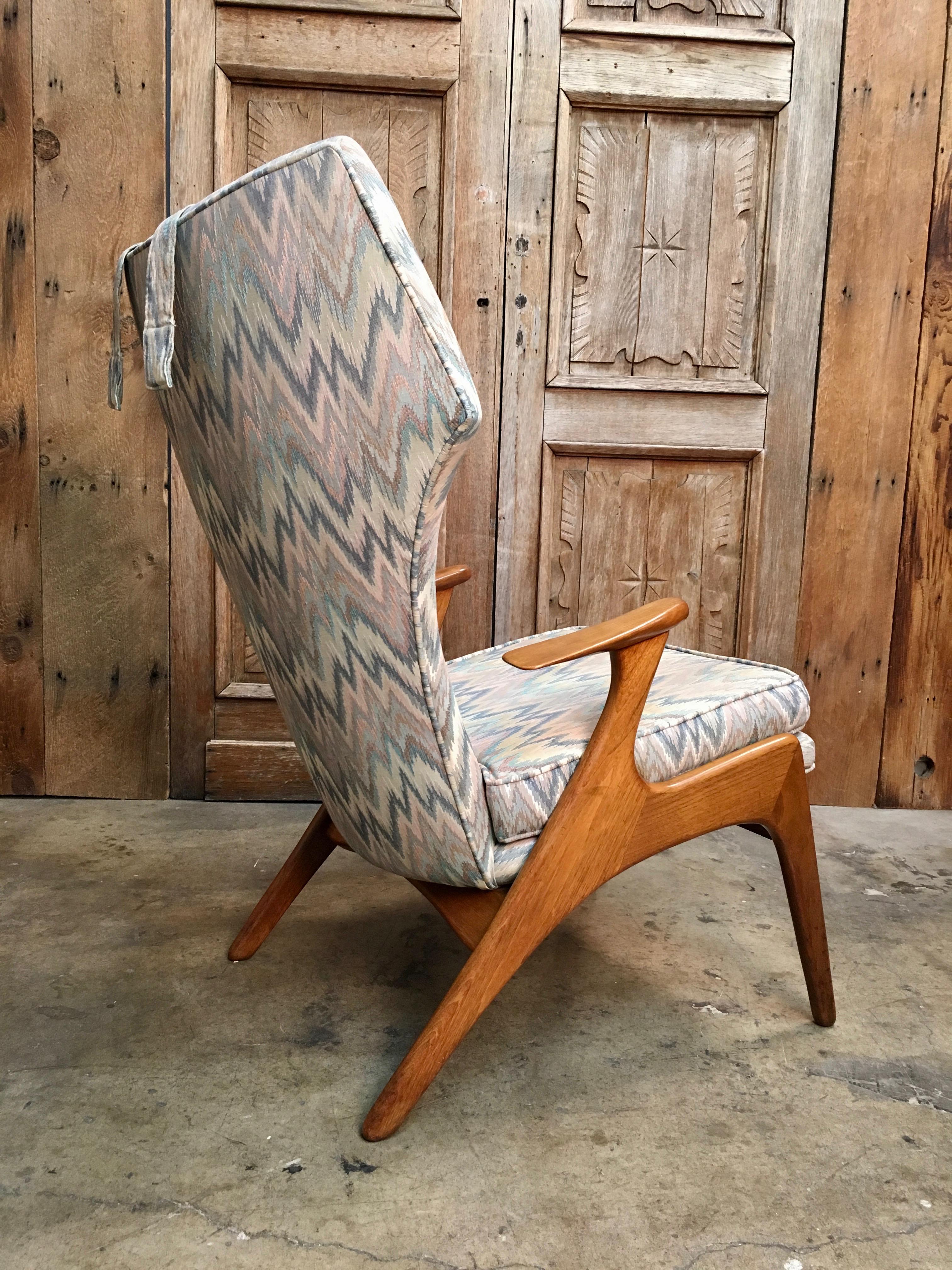 Very comfortable Danish modern lounge chair with the curved high back in original flame stitch fabric and solid oak frame.