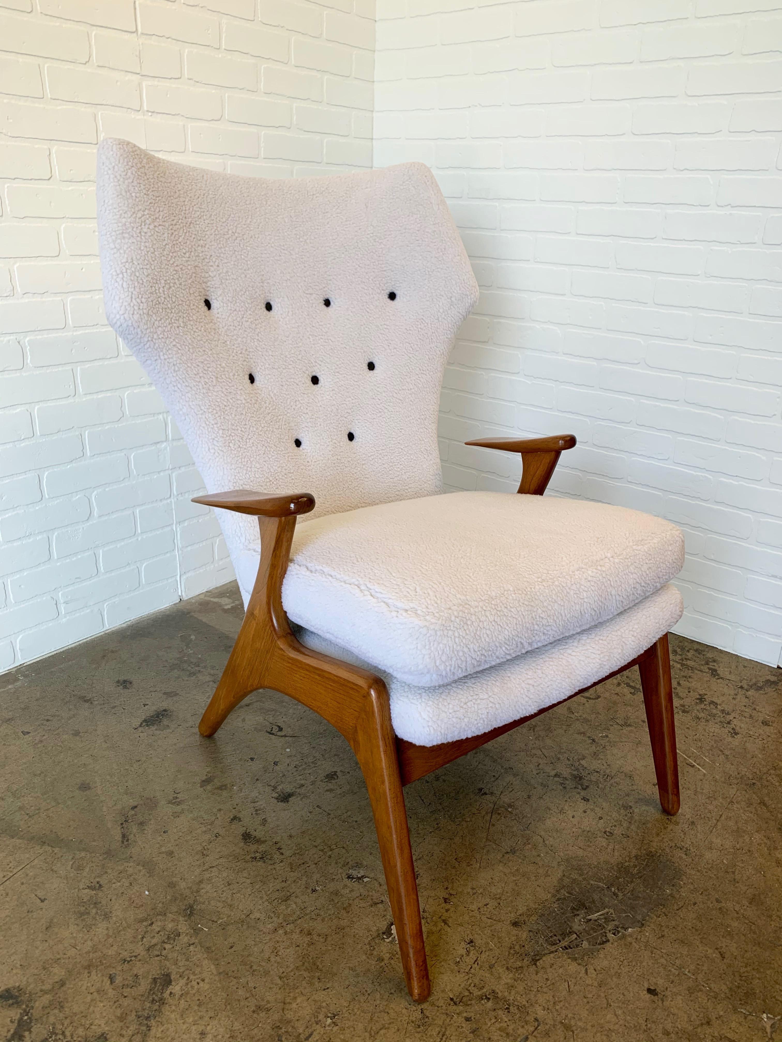 Very comfortable Danish modern lounge chair with the curved high back in sherpa faux teddy fur fabric with black buttons and solid oak frame. This fabric is Ivory a off white color the difference you see are day light and indoor light photos.