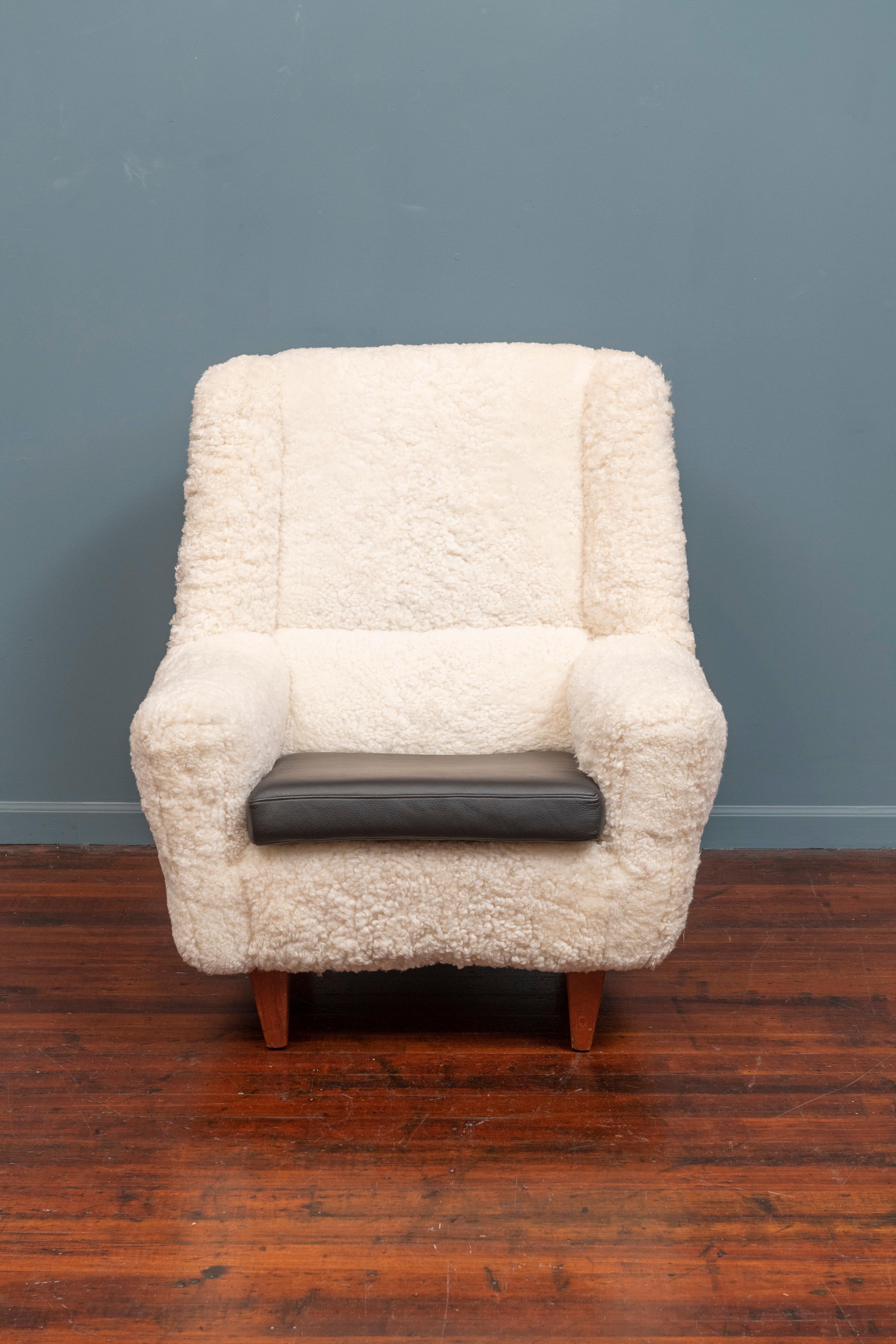 Kurt Ostervig design lounge chair, model 61. Newly upholstered in fluffy inviting lambswool with a new black leather cushion, ready to enjoy.