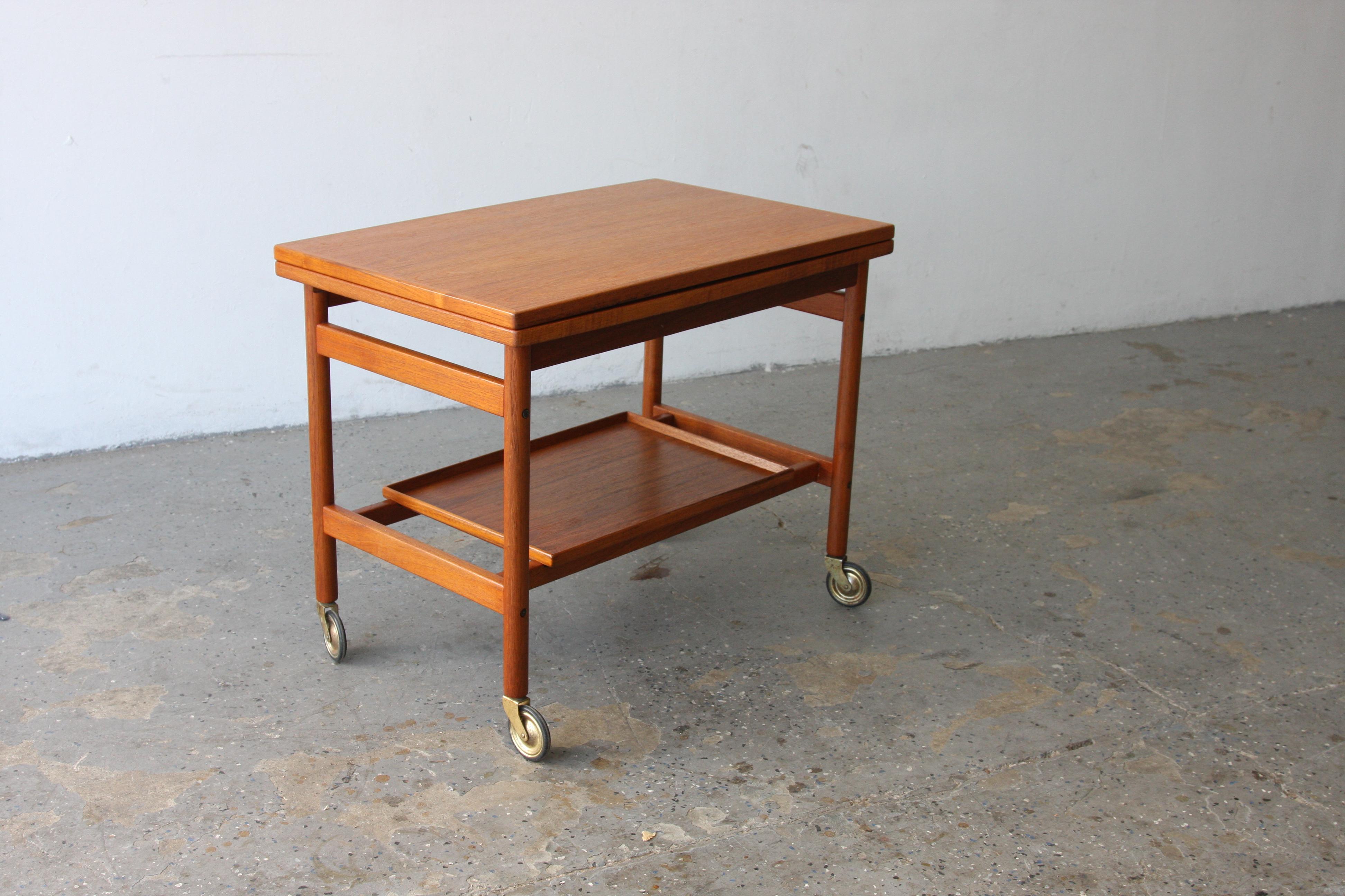 Kurt Ostervig Mid Century Danish Modern Teak Expandable Two Tier Tea Bar Cart

Manufactured by: Jason Møbler
Designer: Kurt Østervig
Place of Origin: Denmark
Period: Mid-Century Modern
Condition: Professionally refinished and restored
Wear: