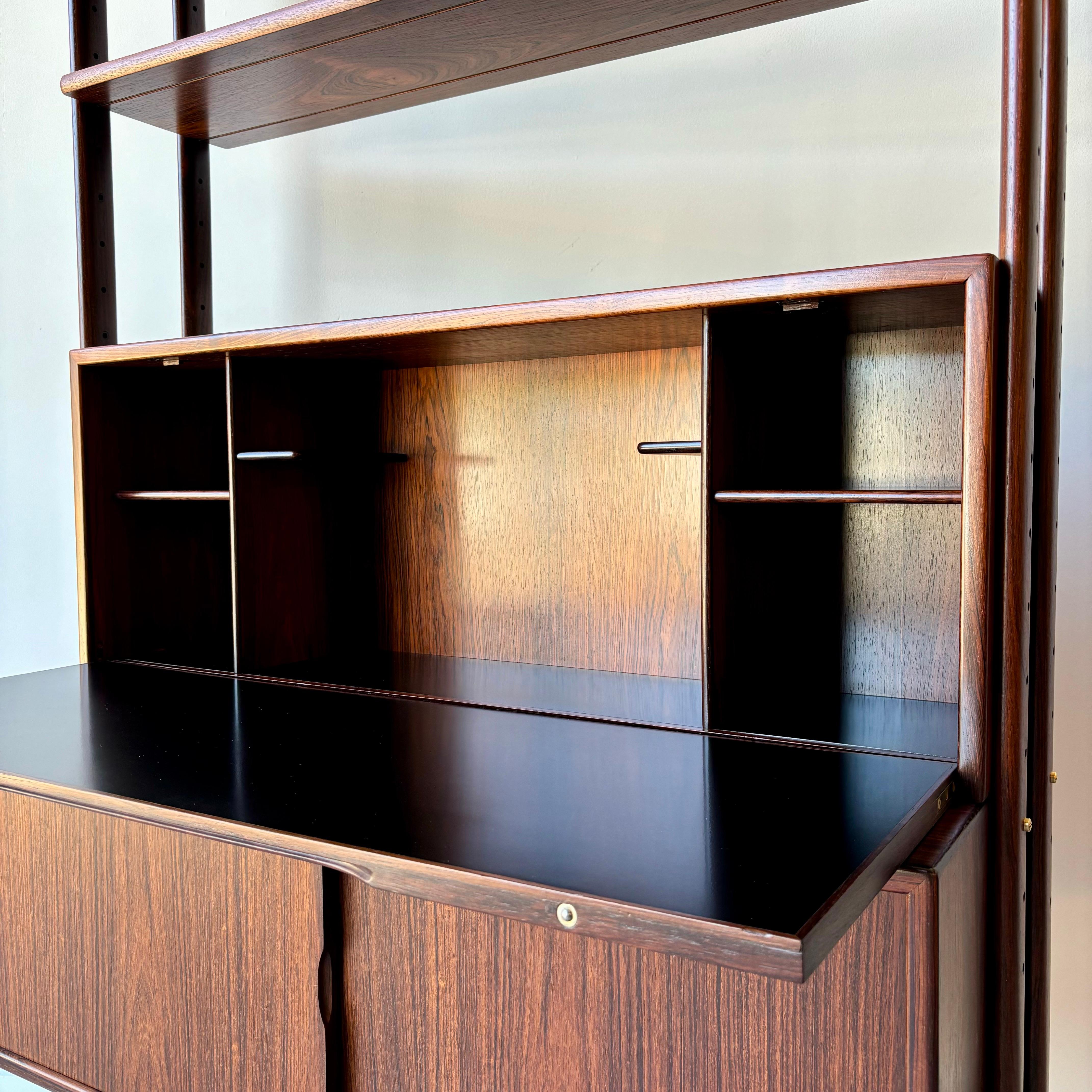 A stunning mid century modern example by Kurt Ostervig.  Sculpted rosewood framed bookcase with storage cabinet and secretary desk.
A fine example fully restored with minor blemishes remaining as shown, presents beautifully.