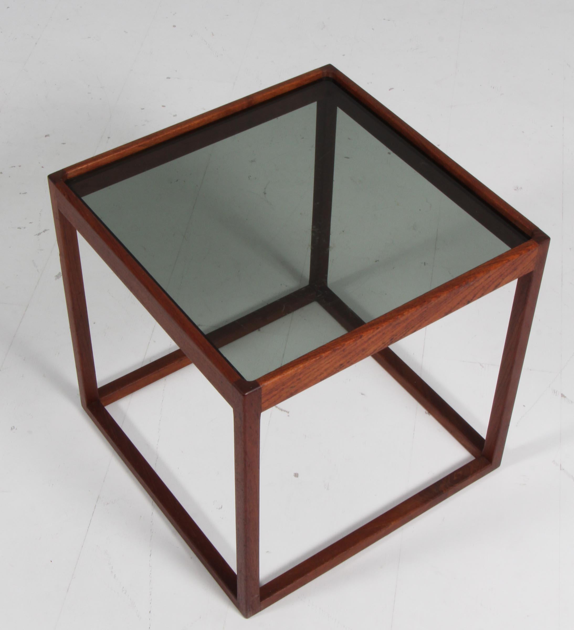 Table cubique Kurt Østervig en teck, avec plateau en verre fumé.

Fabriqué dans les années 1960