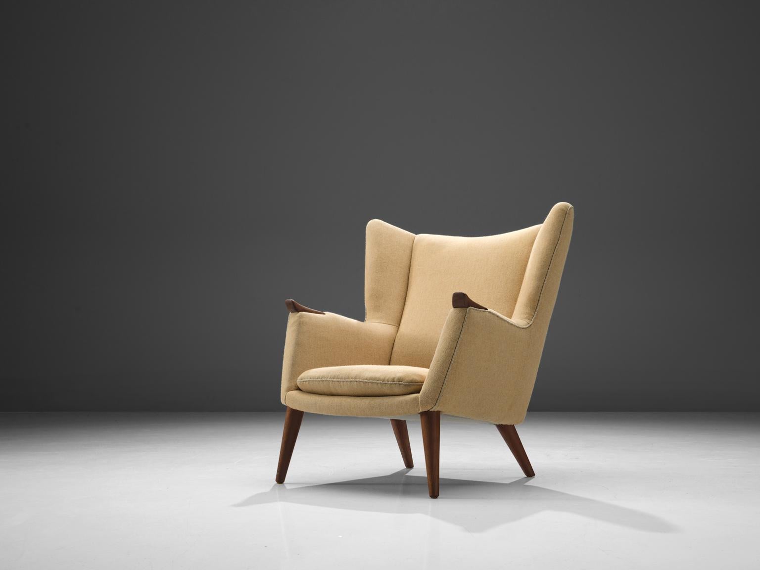 Kurt Østervig, wingback chair, made with yellow fabric and teak, Denmark, 1960s. 

Highly comfortable wingback chair with clear traits of the Danish modern style. This royal design by Østervig has a more solid and closed character. The armrest has a
