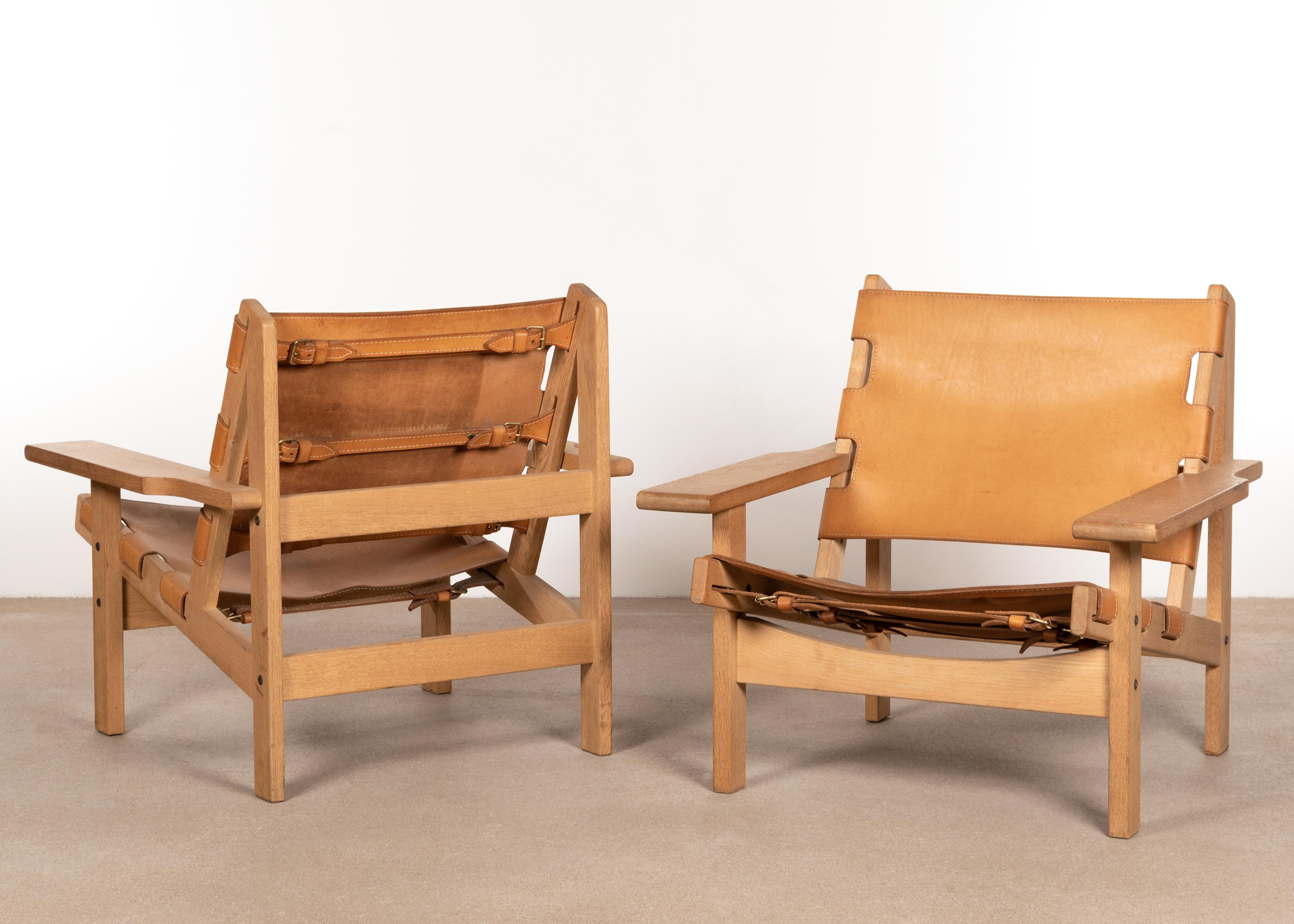 Great pair of hunting chairs (model 168) by Kurt Østervig for K. P. Jørgensens Møbelfabrik, Denmark. Solid oak frames with cognac saddle leather all in good / very good condition. Slight traces of use with beautiful aged leather. Reminiscent of
