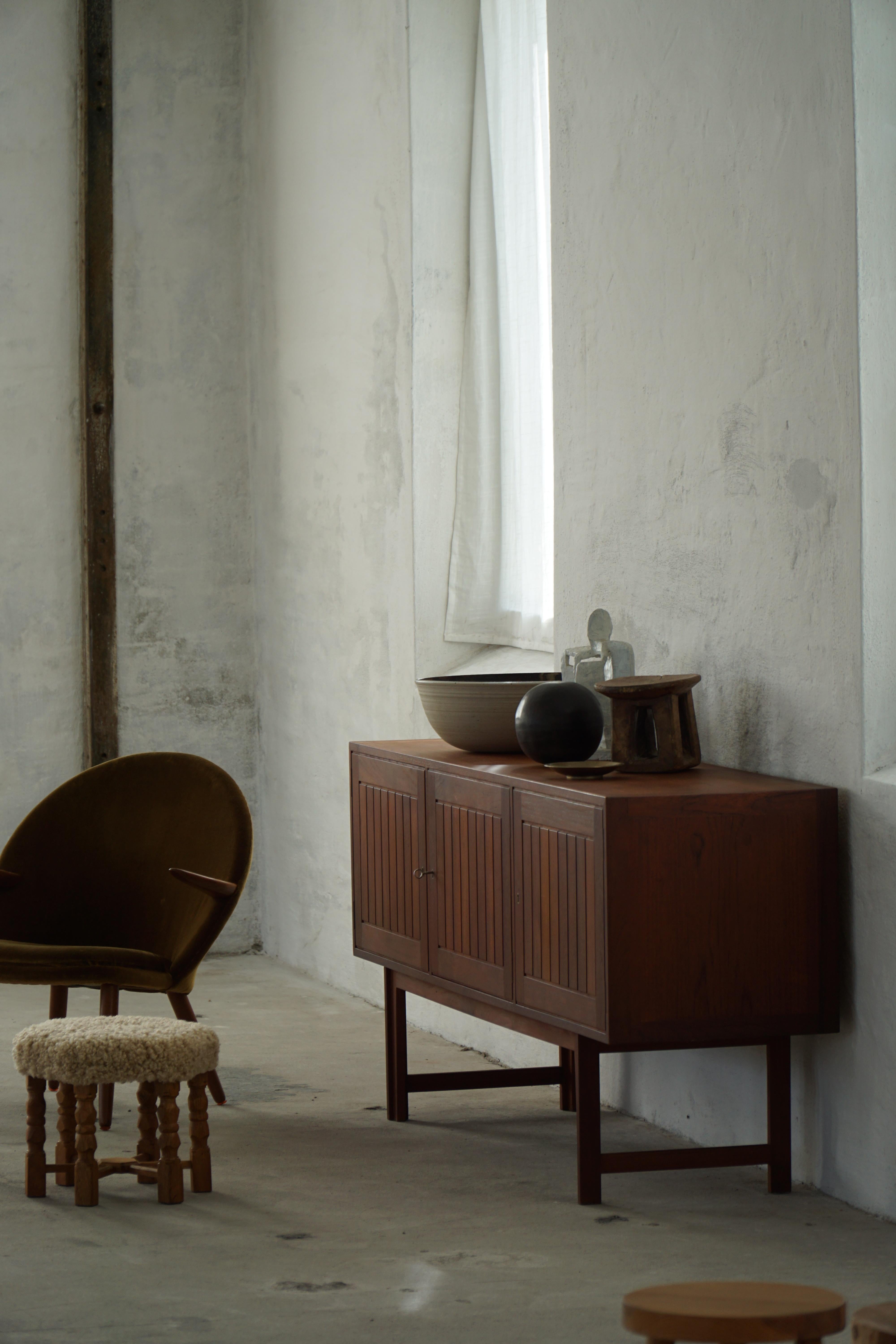 Bellissimo esempio di design danese di metà secolo, questa credenza bassa in teak è stata realizzata dal famoso designer Kurt Østervig e prodotta da Vamo Sønderborg in Danimarca. Il pezzo è caratterizzato da una forma elegante e lineare con un