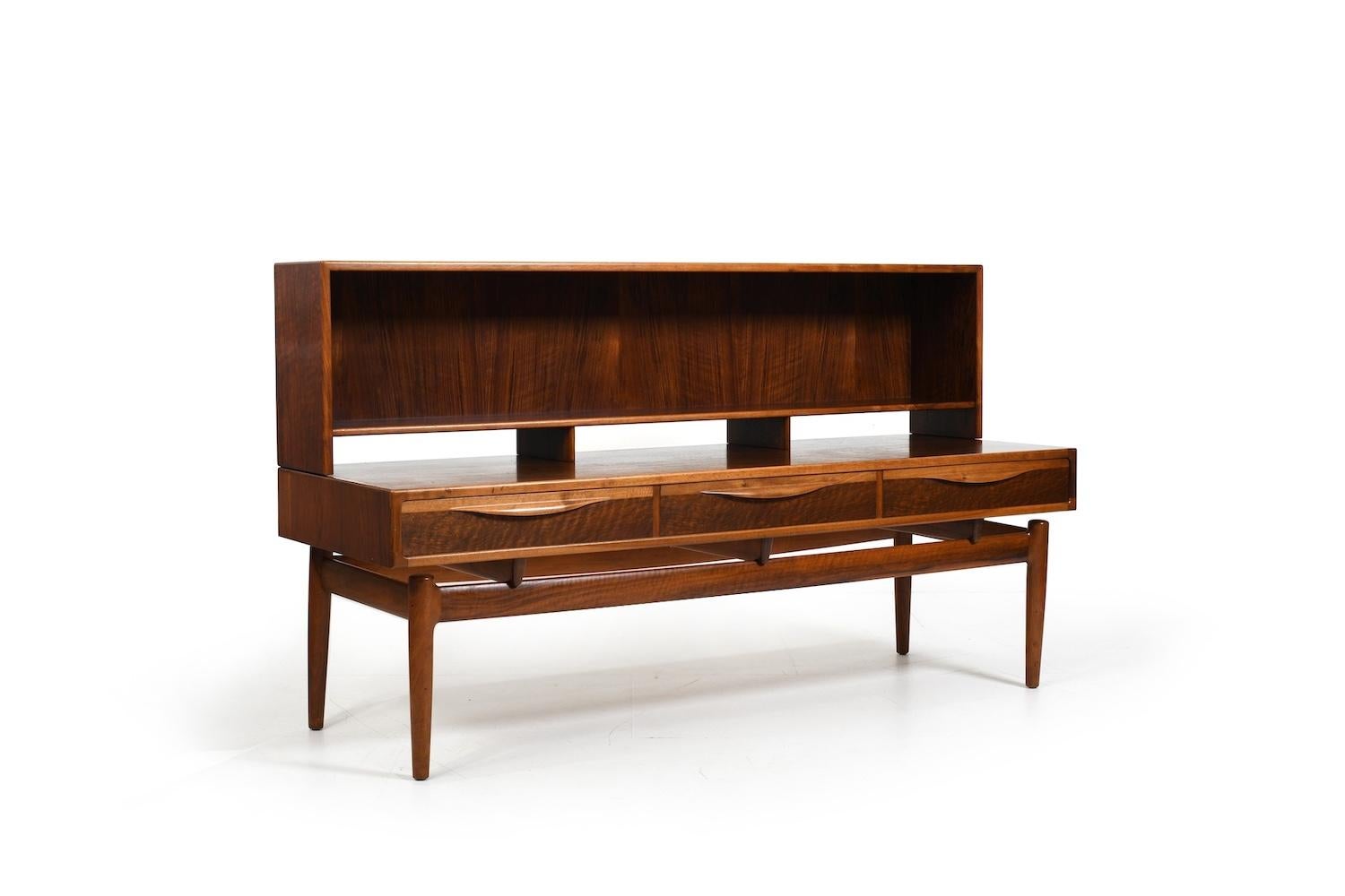 Beautiful danish low sideboard with bookcase top. Design by Kurt Østervig for Brande Møbelindustrie. Denmark, 1950s. Made in finest walnut and oak. In front with 3 drawers and on top an open bookcase.