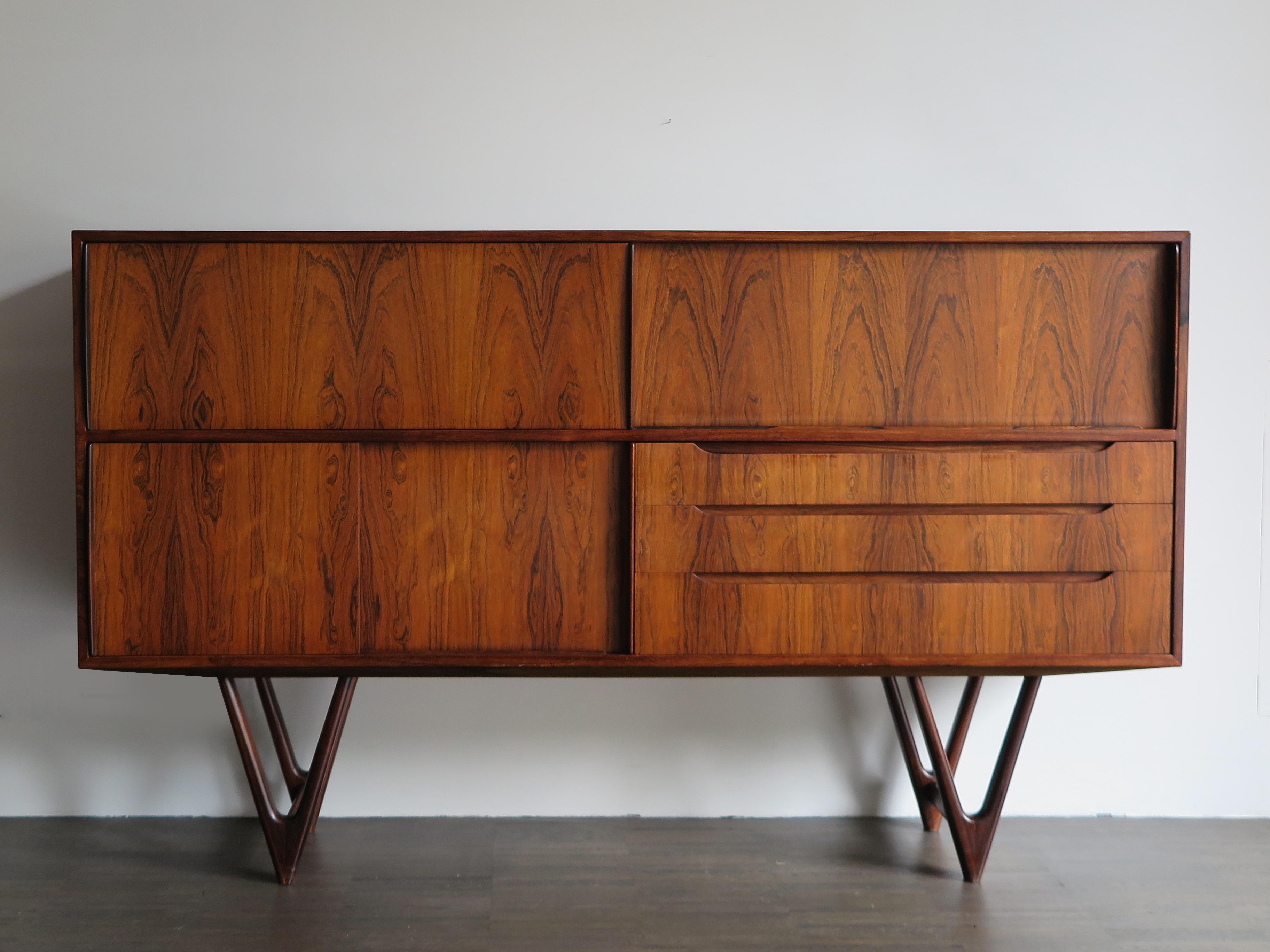 Scandinavian Mid-Century Modern design dark wood hight sideboard designed by Kurt Østervig and produced by Randers Mobelvaerk, with three sliding doors and three drawers, Denmark 1960s
Please note that the item is original of the period and this