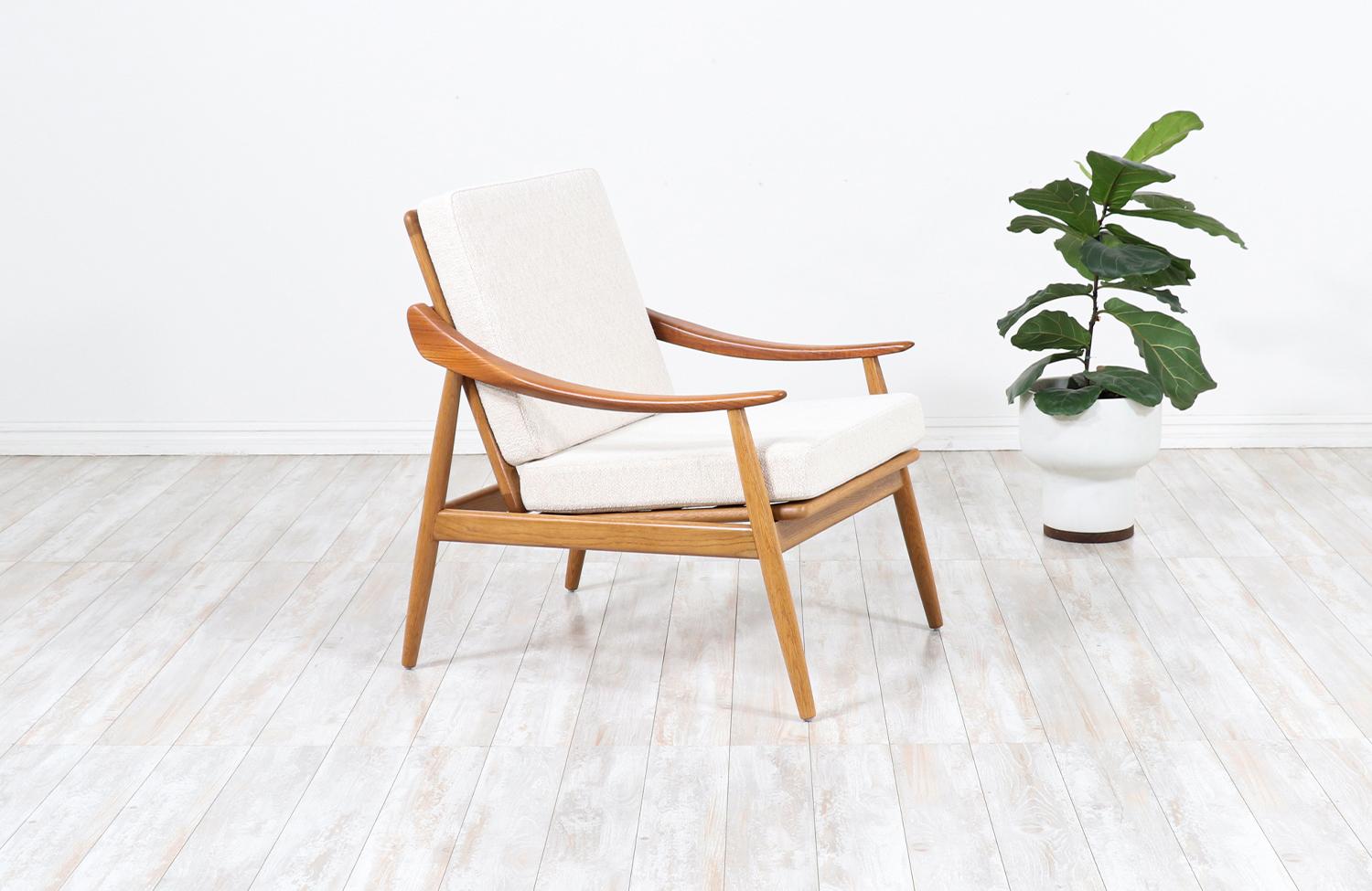 Stylish reclining Danish modern lounge chair designed by Kurt Østervig for Jason Møbler in Denmark in 1956. This beautiful Model-301 lounge chair features a solid oak wood frame with curved teak wood sculpted armrests balancing the design's symmetry