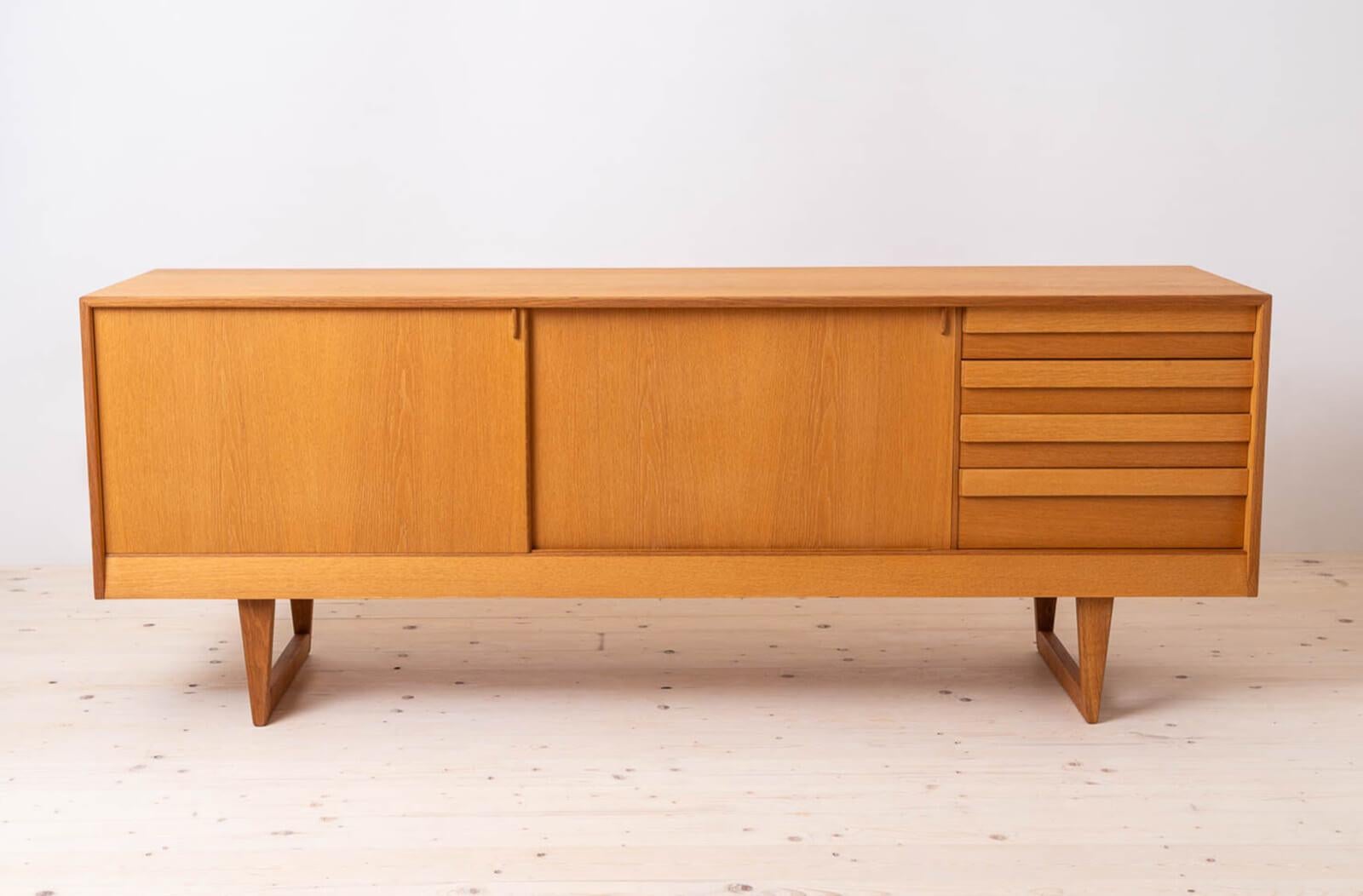 Introducing the sideboard produced by K. P. Møbler manufacture, designed by Kurt Østervig – an exquisite masterpiece that seamlessly blends the timeless elegance of Scandinavian Modern design with the iconic flair of Mid-Century Modern aesthetics,