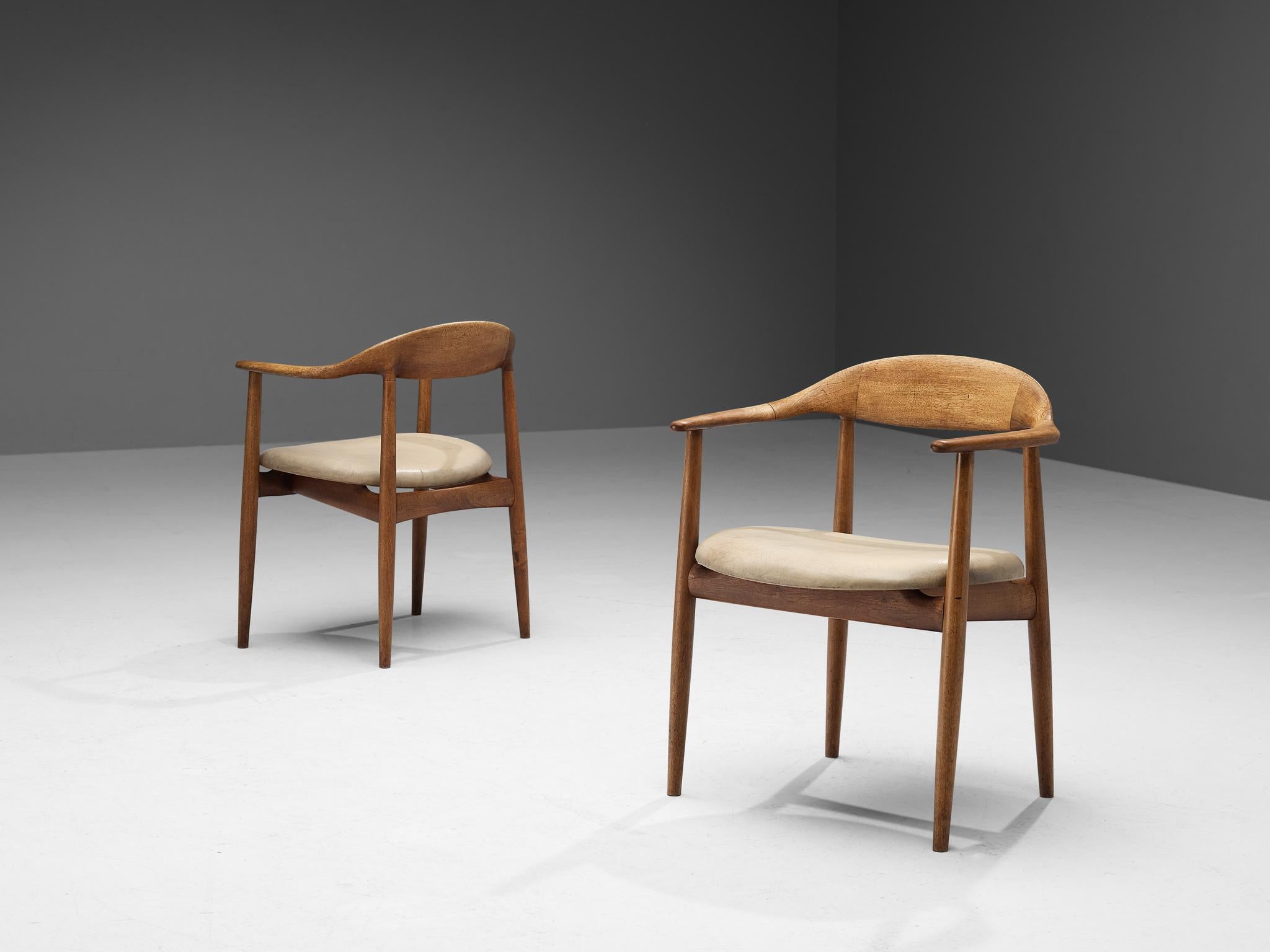Kurt Østervig for Brande Møbelindustri, pair of armchairs model 27, teak, leather, Denmark, 1950s.

Beautiful pair of dining chairs designed by Kurt Østervig for Brande Møbelindustri. This organic looking pair of armchairs is made with an