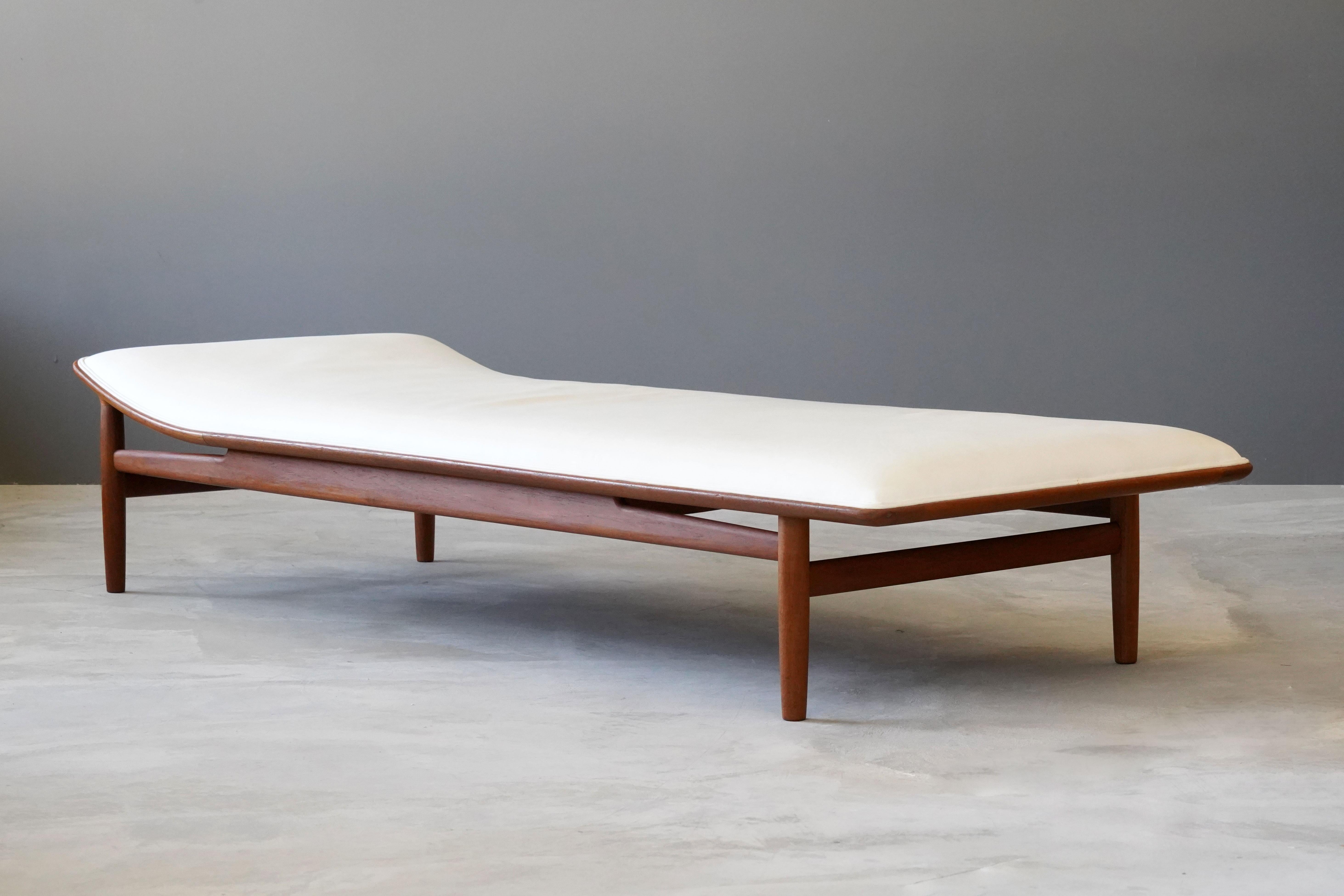 A rare modernist daybed, designed by Kurt Østervig and produced by Jason Møbler, 1950s. Branded. In finely carved teak, leatherette is most likely secondary. 

Contemporary Danish designers include Finn Juhl, Hans Wegner, Arne Jacobsen, and Poul