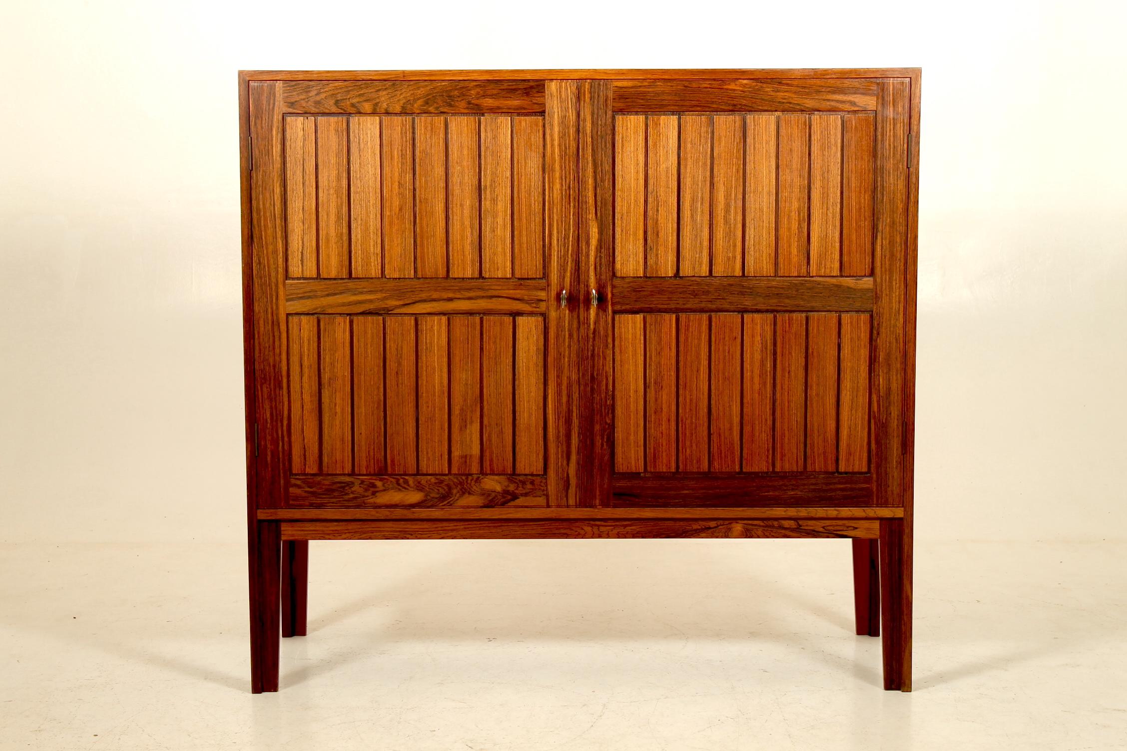 Cabinet with two doors, adjustable shelves and solid rosewood drawers inside. Designed by Kurt Østervig in the 1960s and manufactured by VAMO Sønderborg, Denmark. Original receipt from 1964 inside.
	
