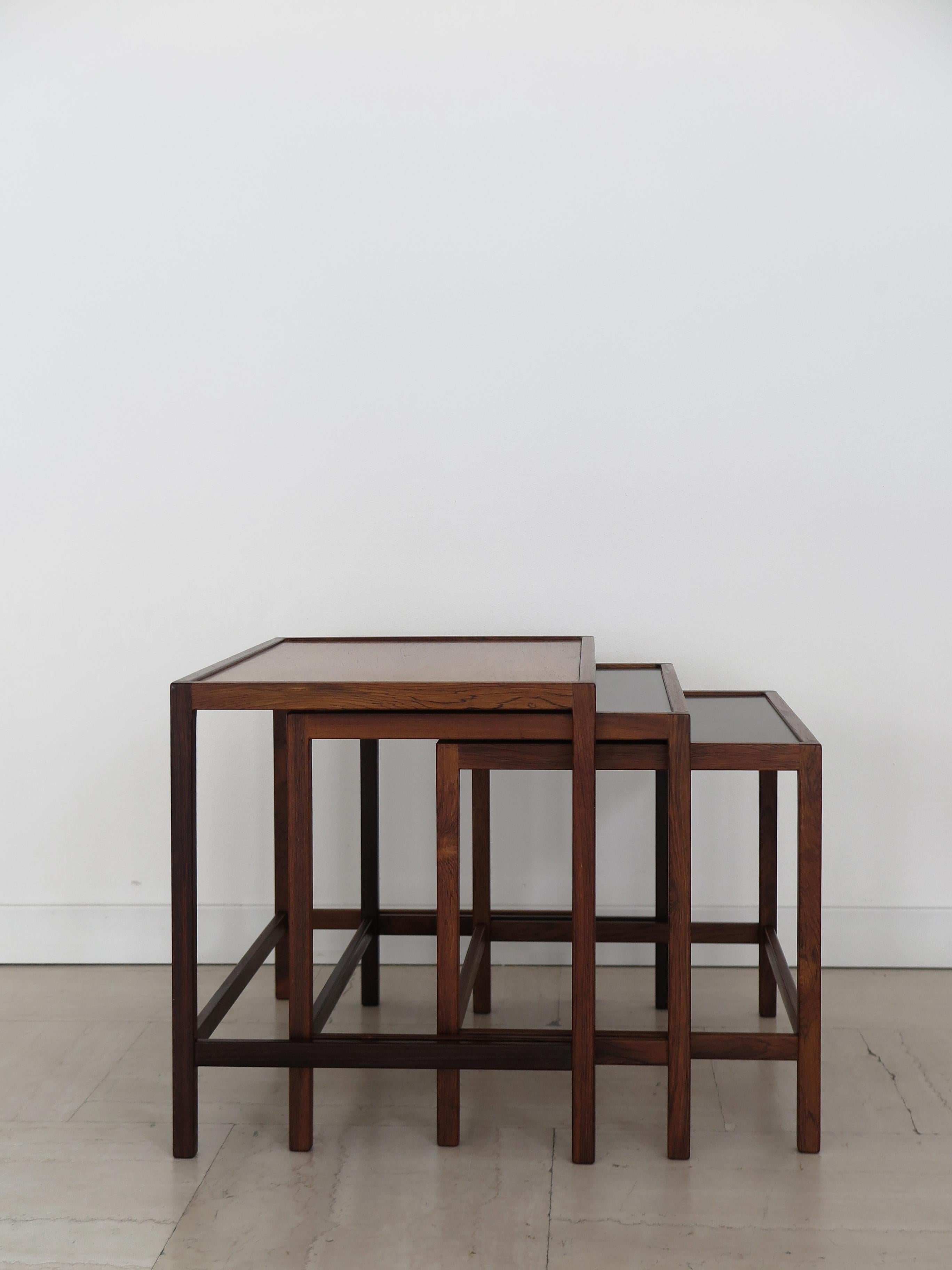 Set di tre tavolini da nido dal design scandinavo di metà secolo, disegnati da Kurt Østervig con struttura in legno massiccio scuro e piano in legno e formica nera, Danimarca, anni '60. 

Si prega di notare che l'oggetto è originale dell'epoca e