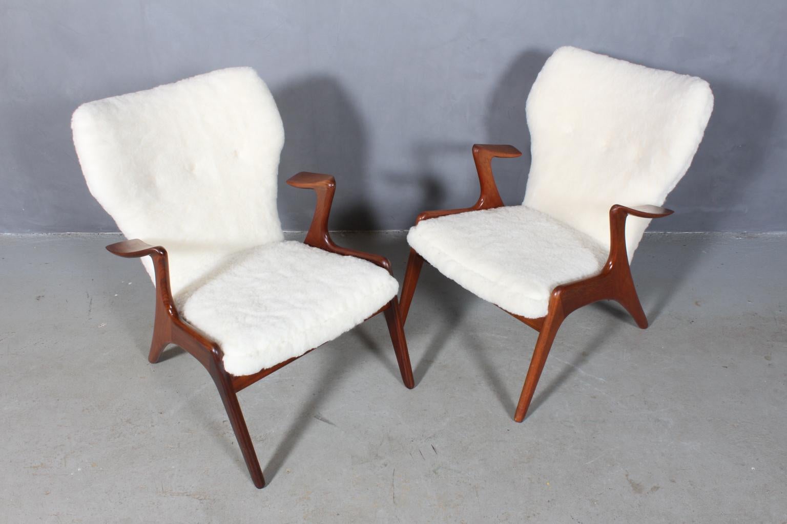 Kurt Østervig set of lounge chairs new upholstered with sheepskin with buttons.

Organic shaped frame of solid teak.

 