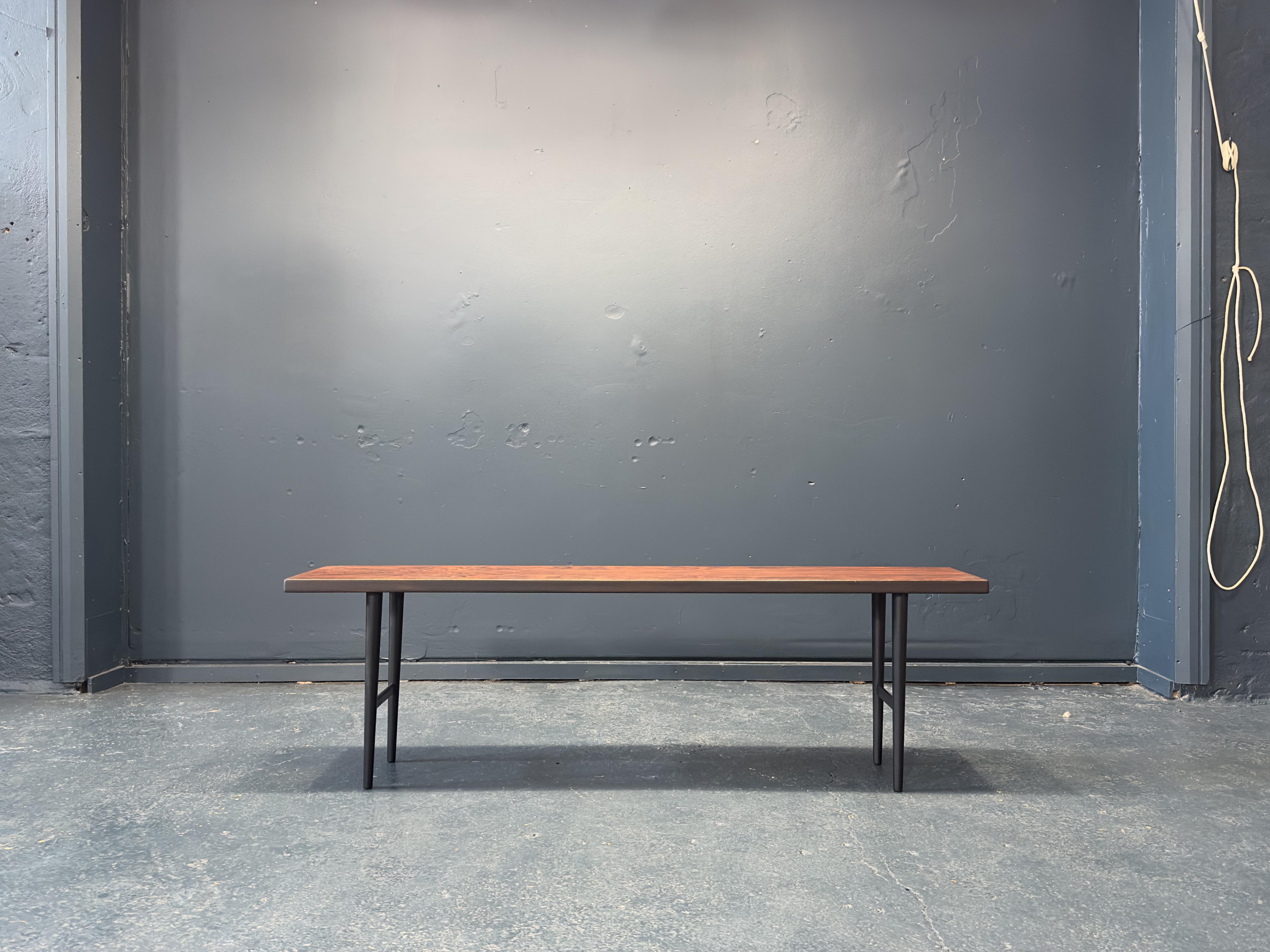 This low hardwood table was designed by Kurt Østervig in the 1960's for Jason Møbler. This piece features a gorgeous hardwood table top with incredible colouration and deep rich grain. The tabletop is set on black lacquered legs. With its low height
