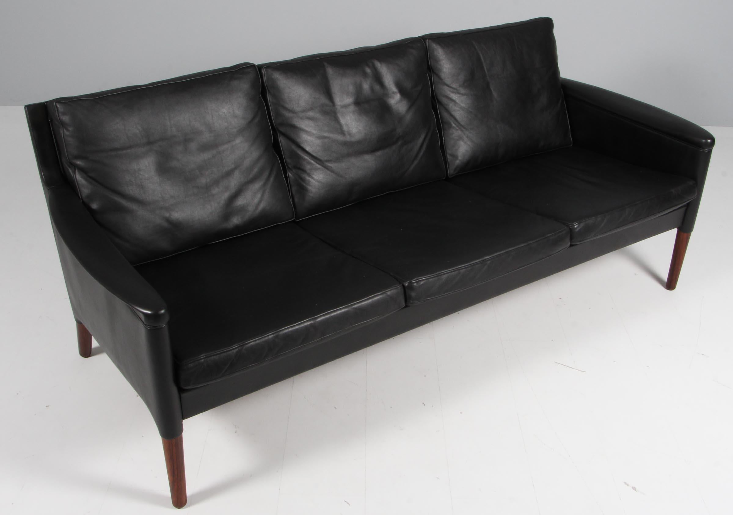 Kurt Østervig three seater sofa in original black leather.

Legs of rosewood.

Made by Centrum Møbler in the 1960s